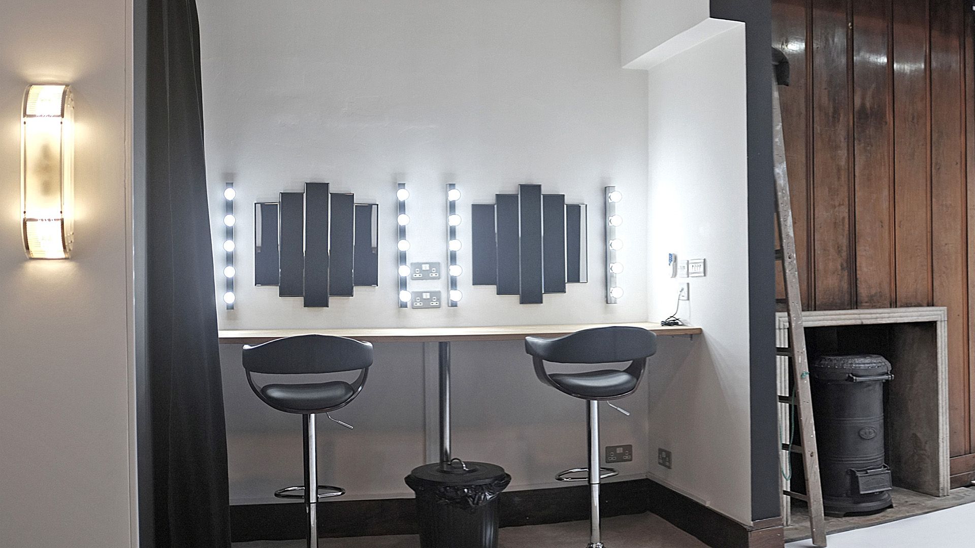 Modern makeup station with well-lit mirrors for event professionals' pre-performance prep.