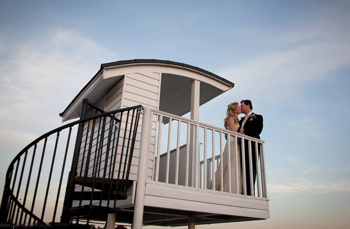 Couple in formal attire on Ham Polo Club rooftop terrace, perfect for romantic weddings.