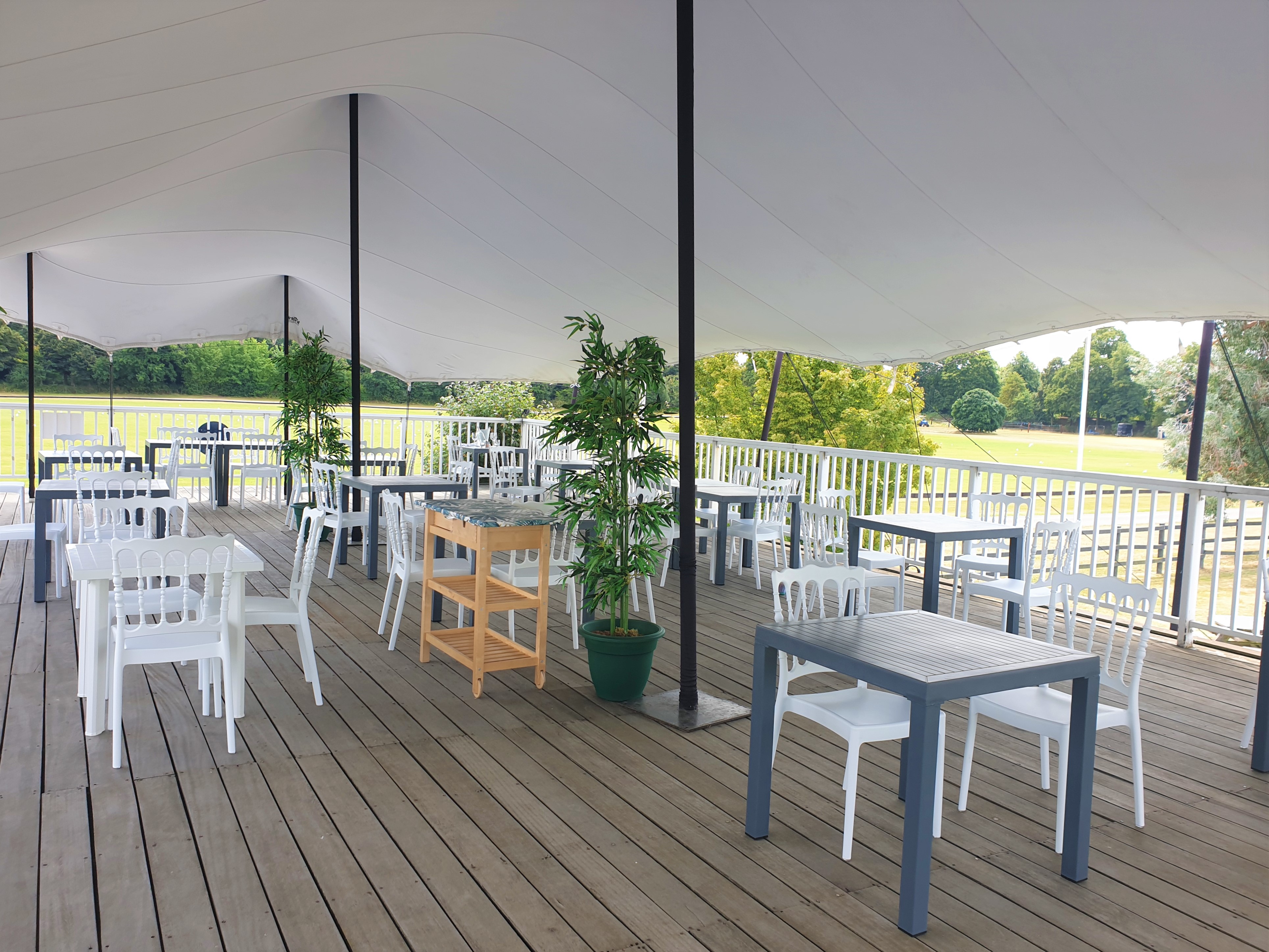 Rooftop terrace at Ham Polo Club with white tables, perfect for outdoor events and gatherings.