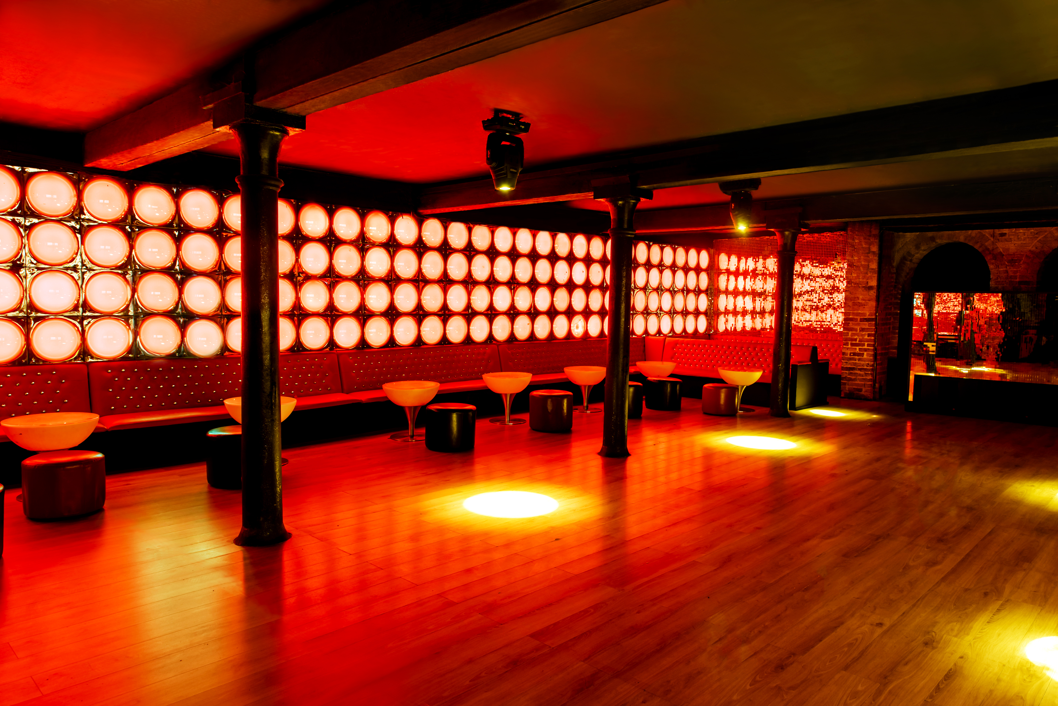 Vibrant La Pollera Colora event space with red lighting, ideal for parties and networking.