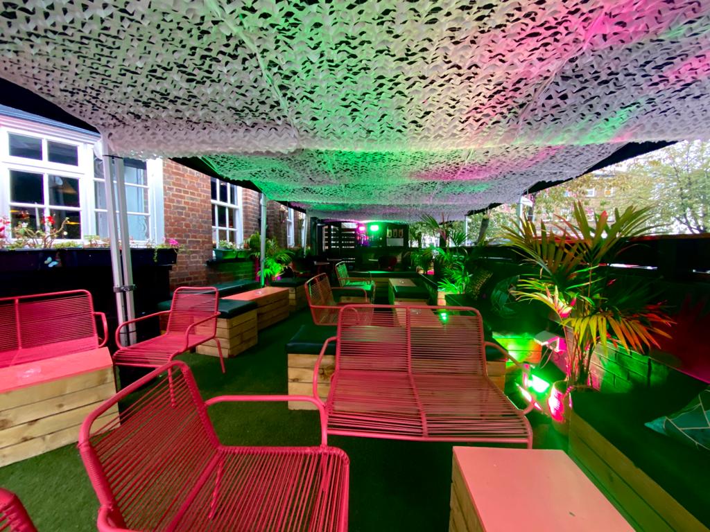 Vibrant outdoor event space at Biddy Mulligan's Olympia with modern seating for social mixers.
