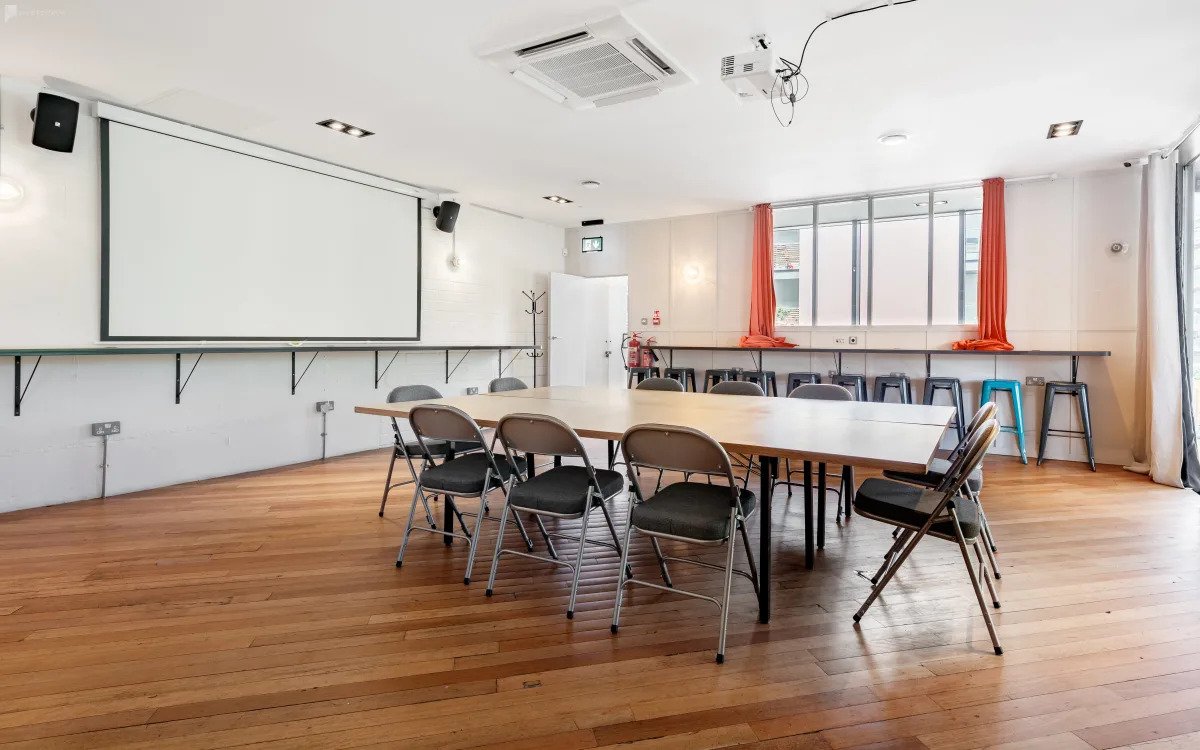 Versatile conference space with large table, ideal for workshops and meetings.
