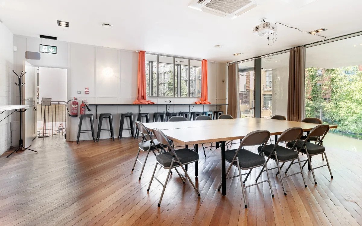 Versatile conference space with large table, ideal for workshops and meetings.