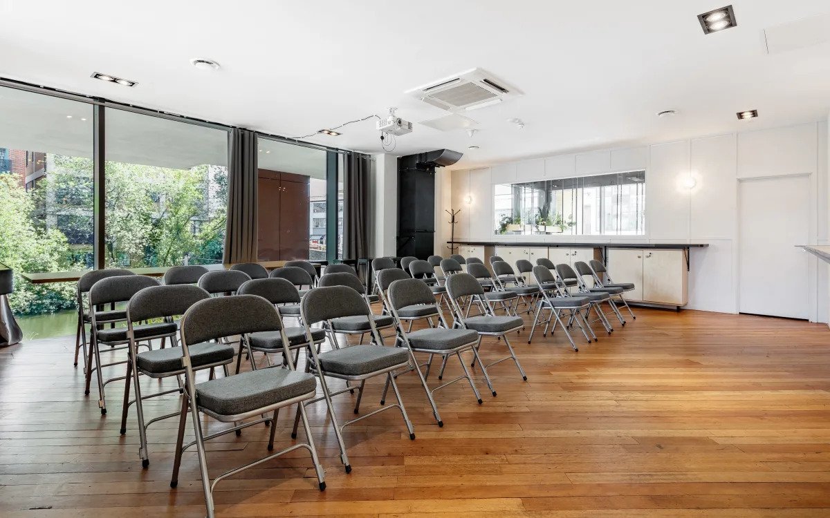 Versatile conference space with natural light, ideal for workshops and presentations.
