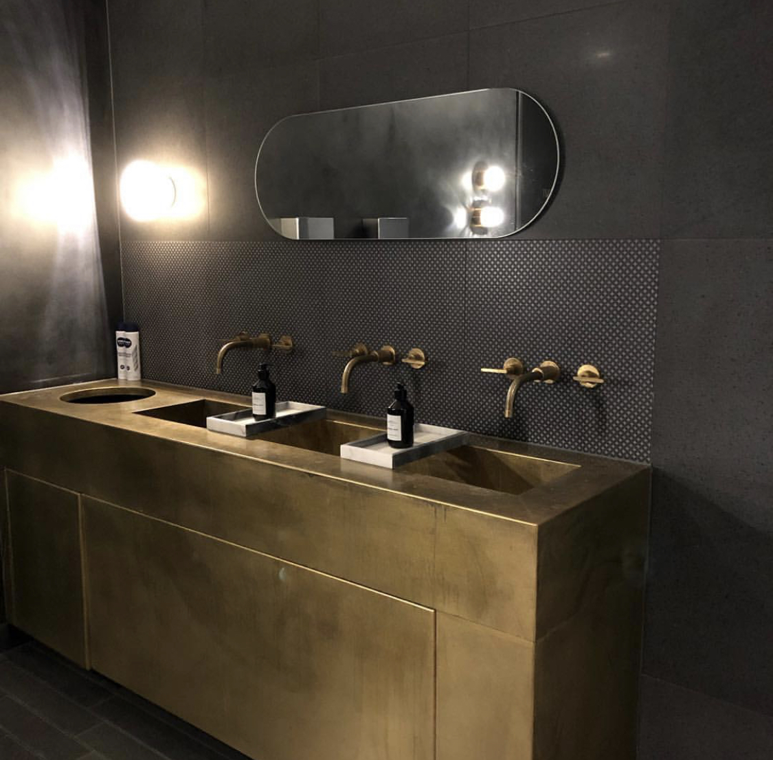 Modern restroom with brass fixtures and marble sinks for upscale events at The Fore.