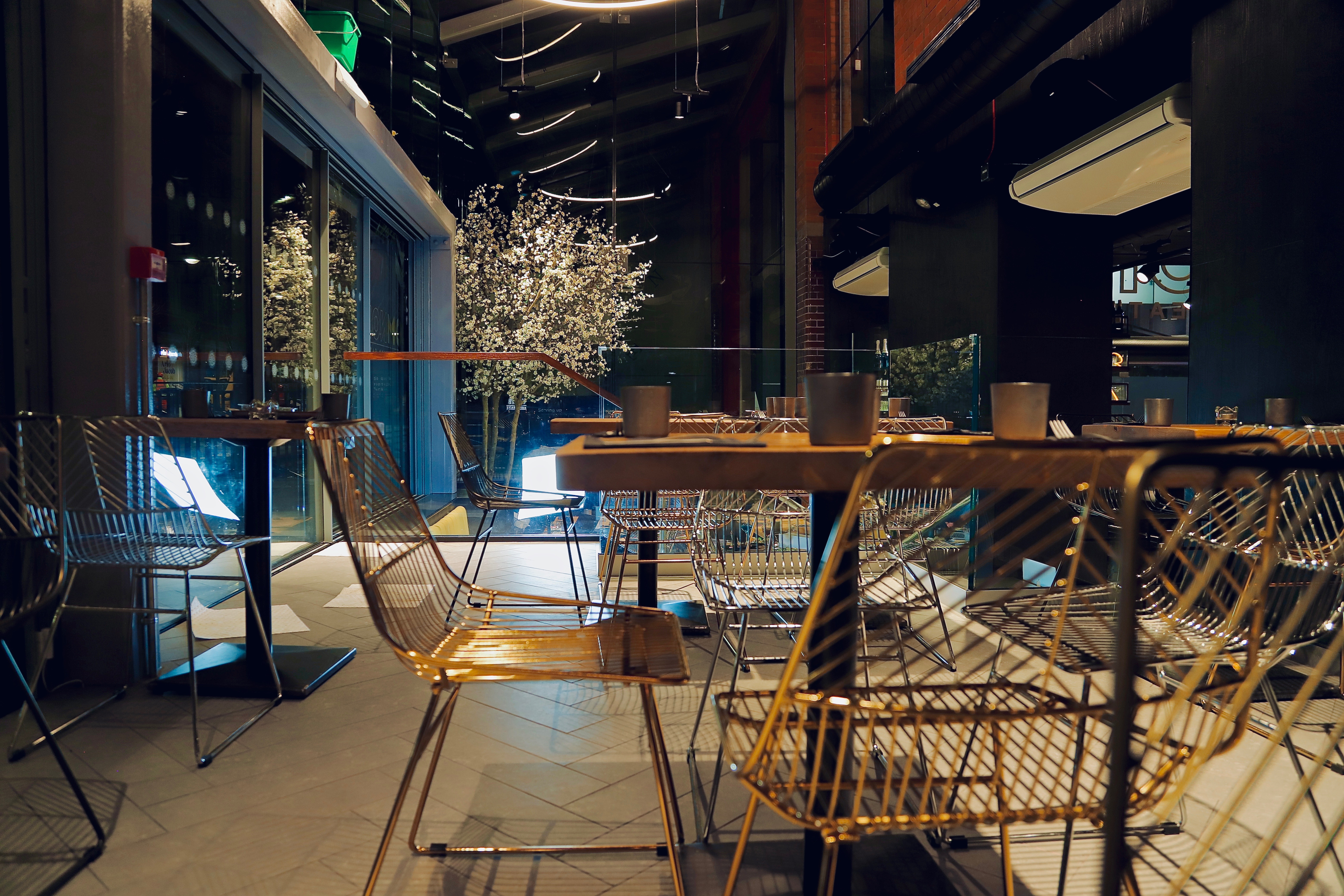 Modern event space in OmNom with stylish wire chairs and flexible seating for gatherings.
