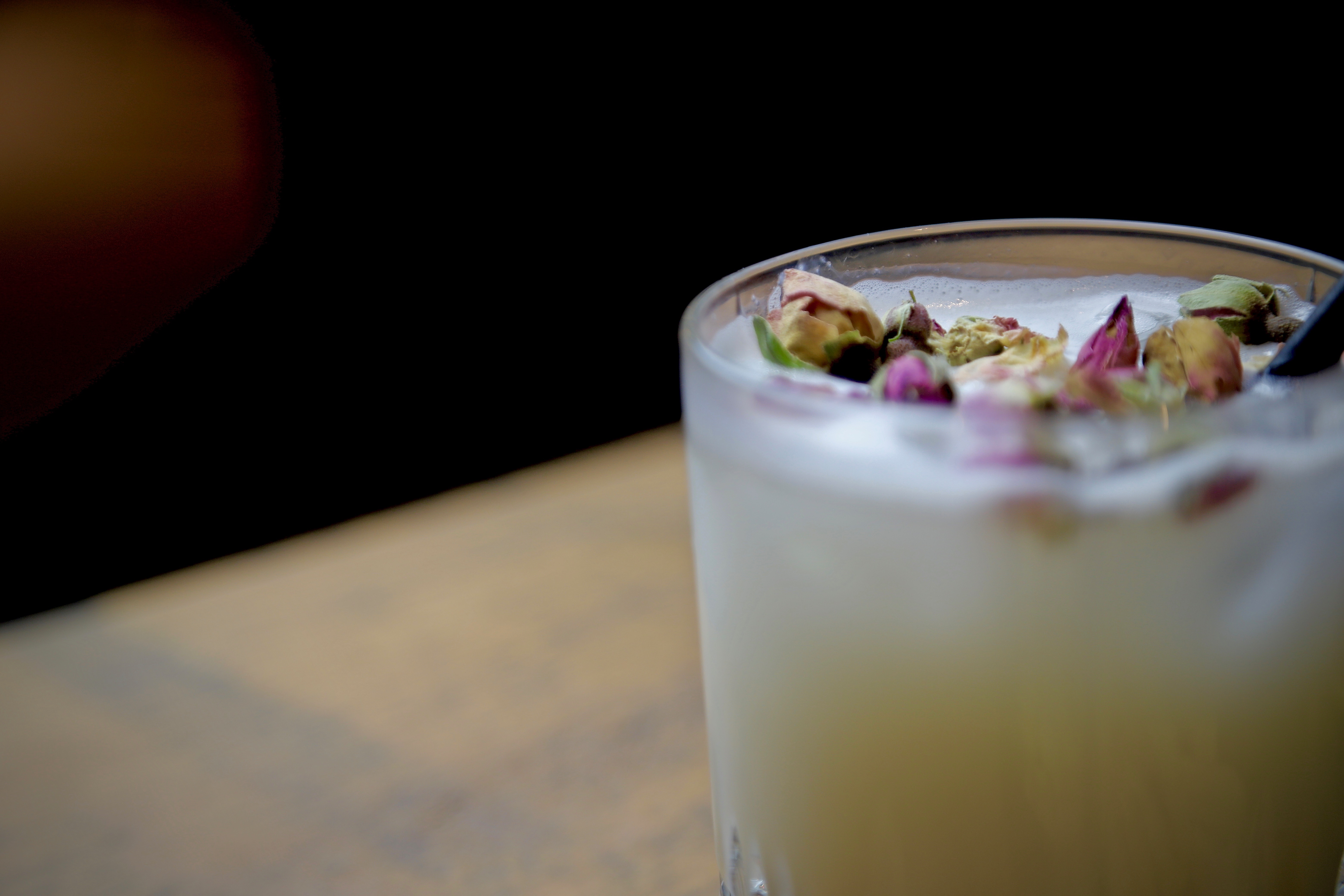 Signature cocktail garnished with rose petals at OmStudio, perfect for events and meetings.