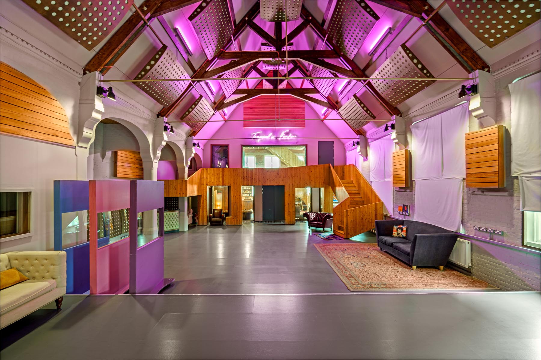 Modern event space with high ceilings and purple lighting for networking and gatherings.