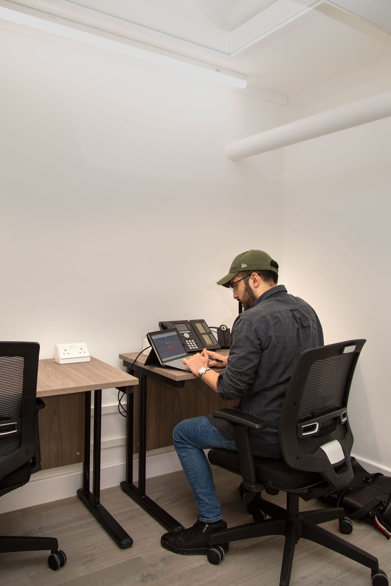 Focused professional in minimalist workspace, ideal for hybrid events and logistics planning.