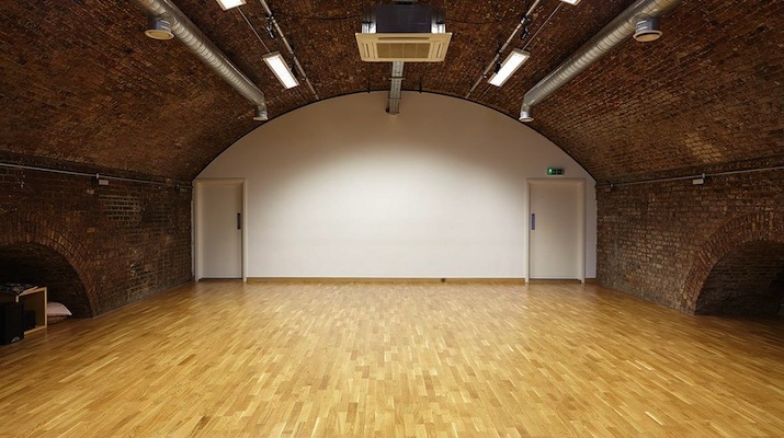 Versatile event space with arched brick ceiling, ideal for workshops and gatherings.