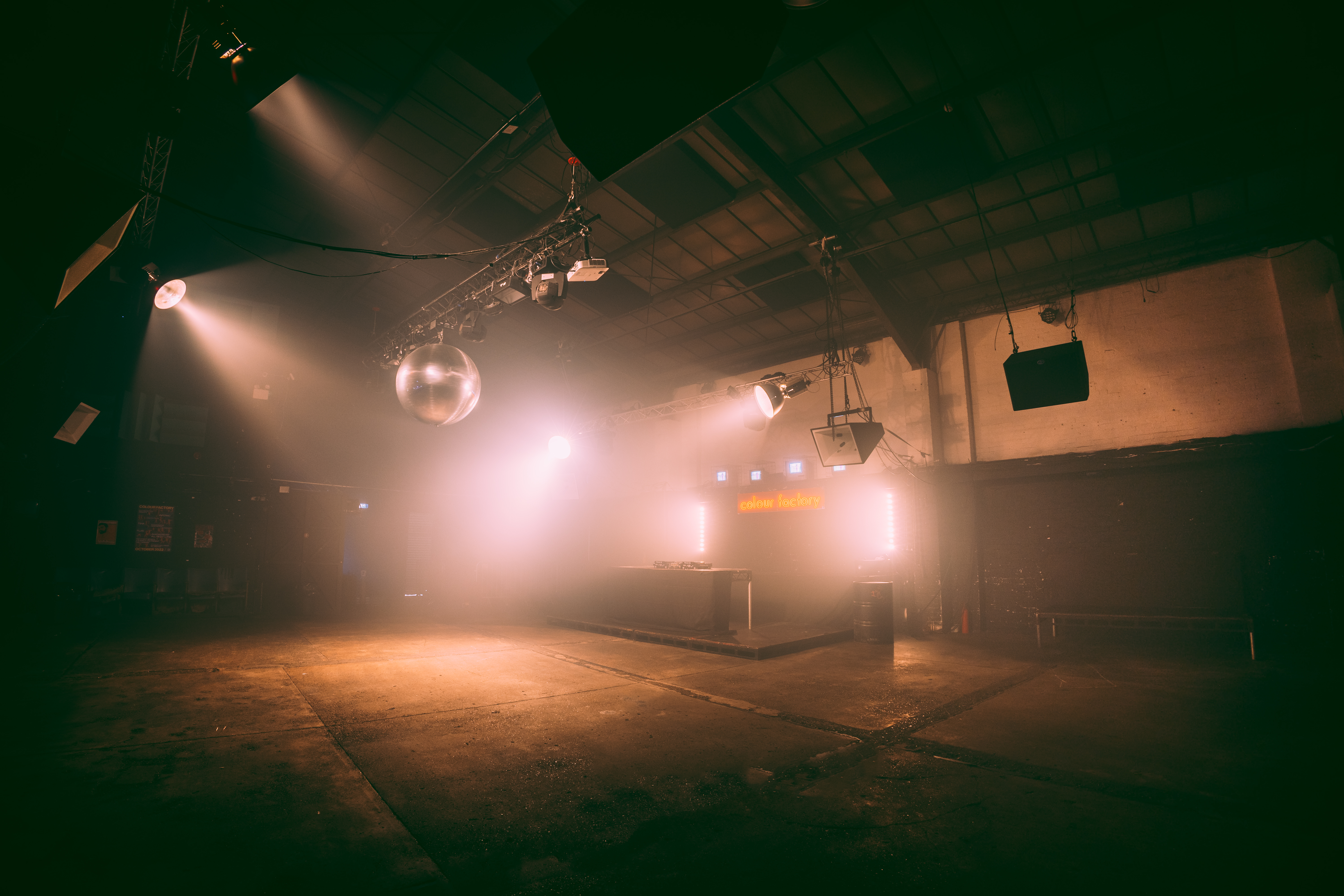 Versatile industrial event space with disco ball for corporate and social gatherings.