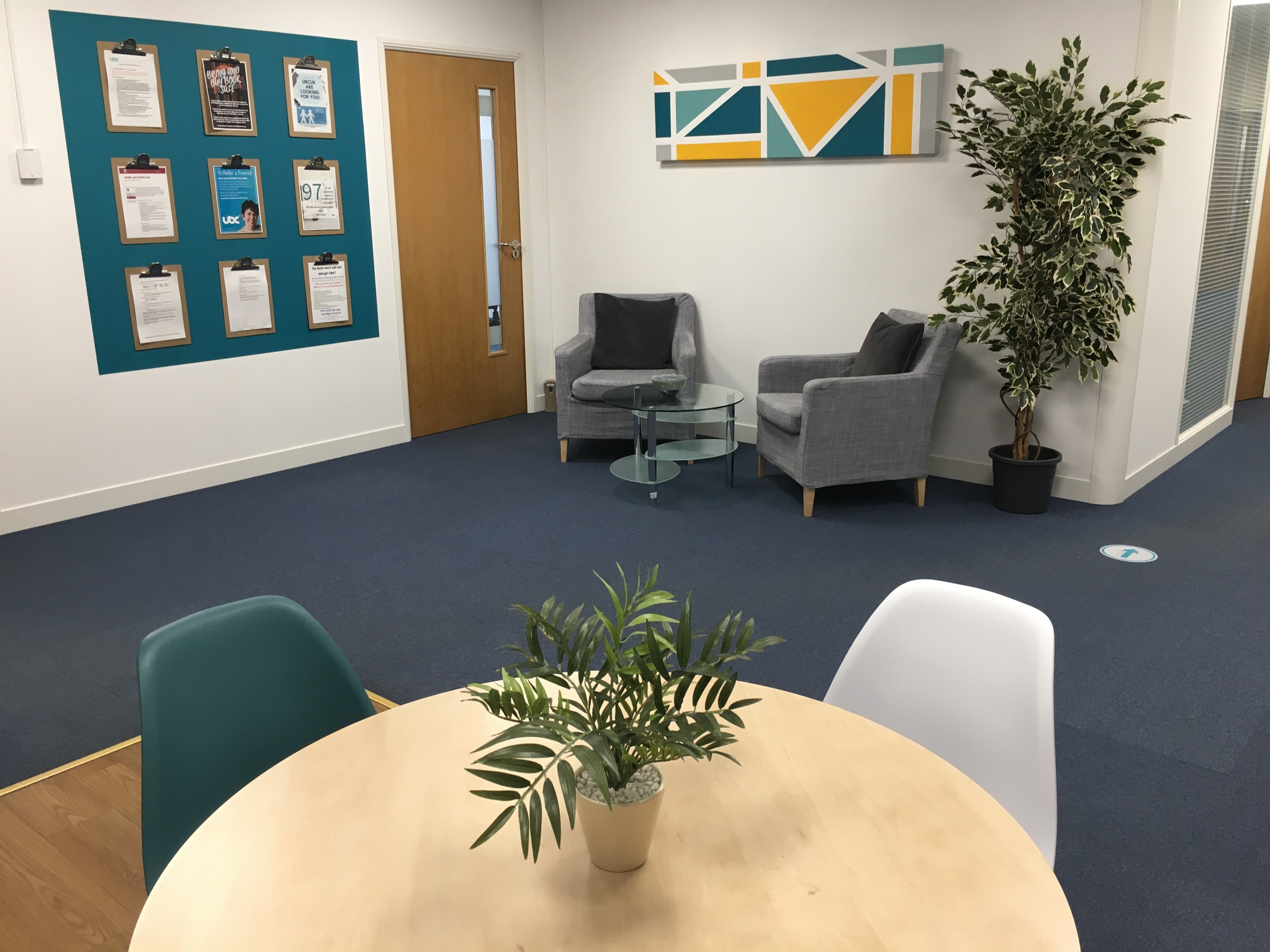 Modern meeting space at UBC Henley, featuring inviting seating and greenery for events.