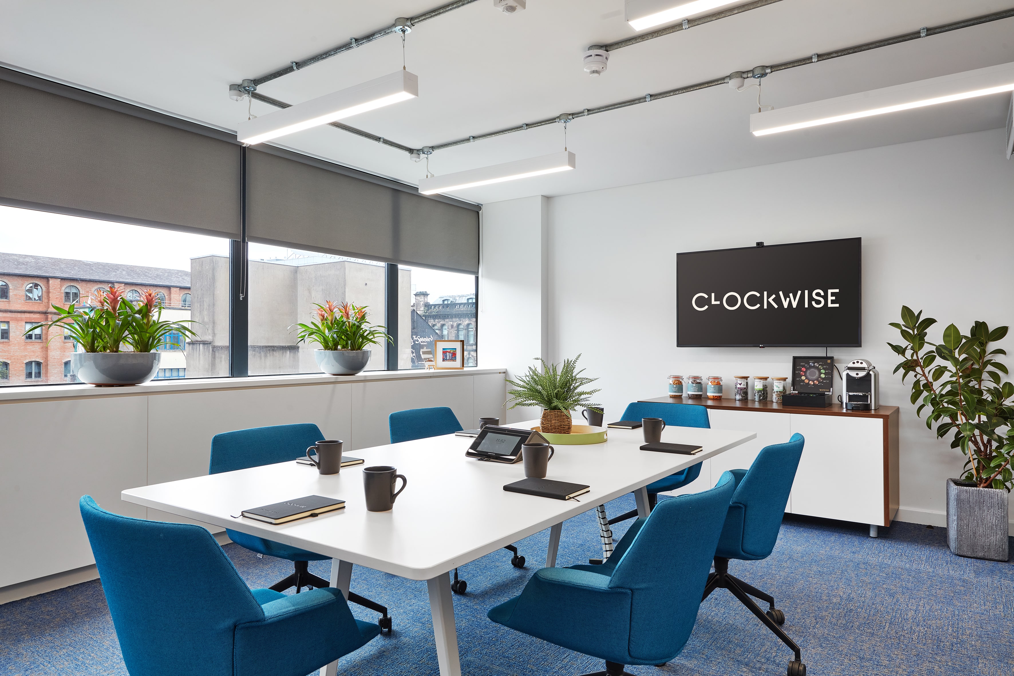 Modern meeting room in Clockwise Offices with blue chairs and natural light.