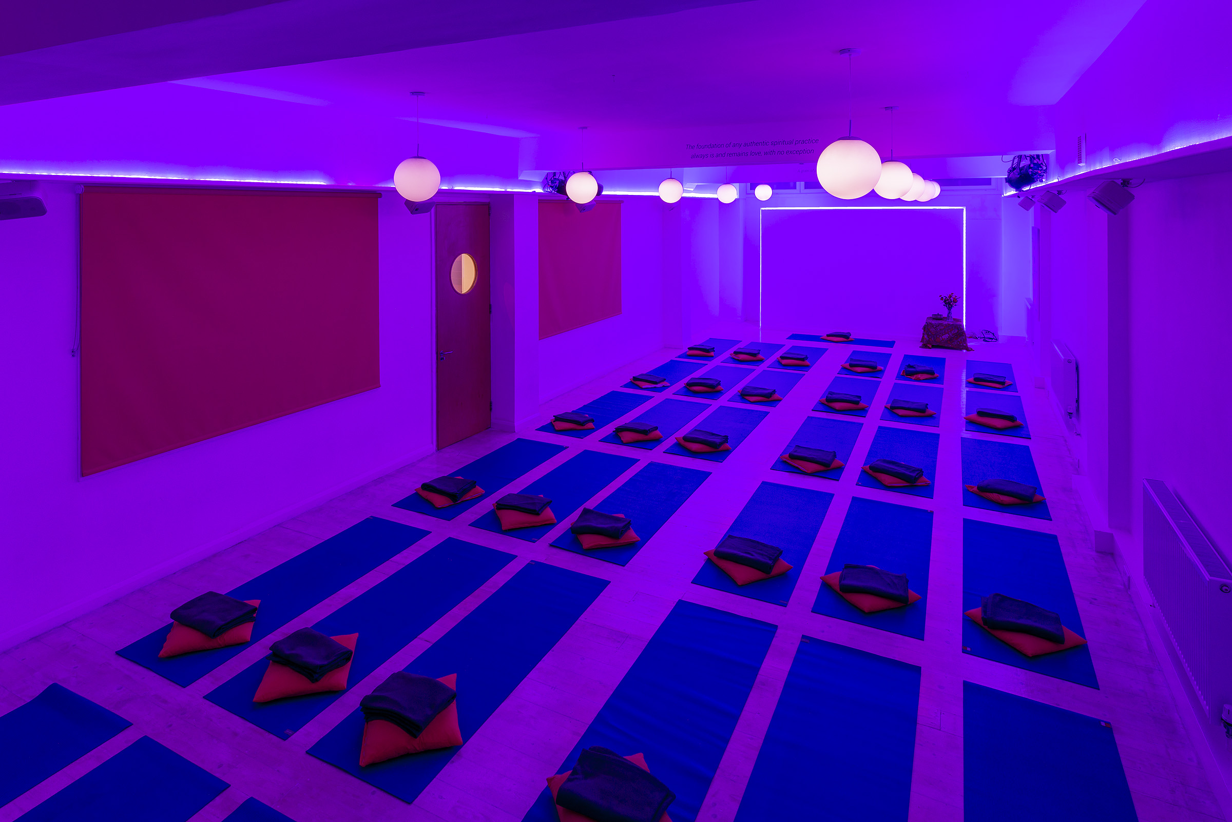 Serene yoga studio with purple lighting, ideal for wellness retreats and mindfulness workshops.