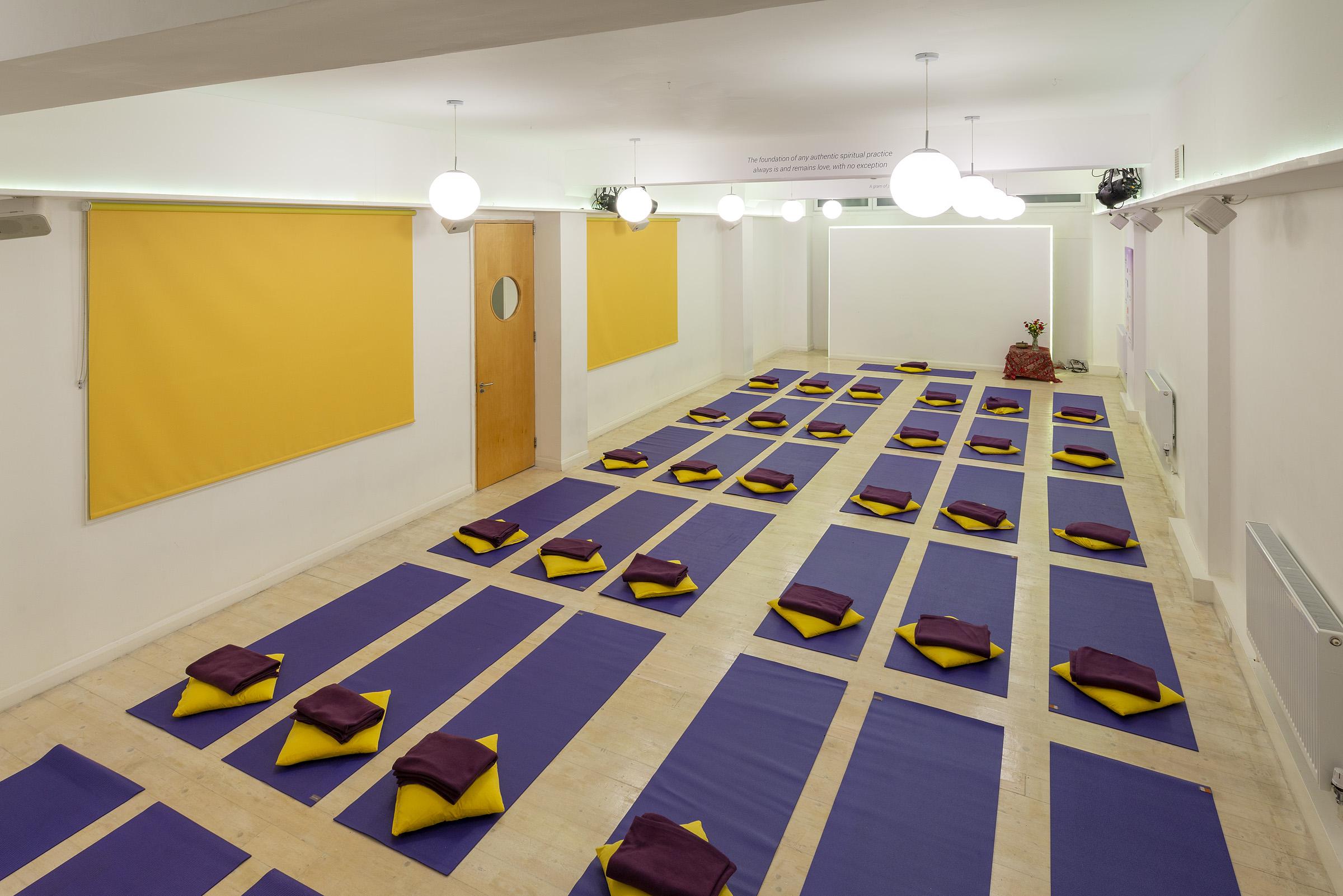 Serene yoga studio with mats and cushions, ideal for wellness retreats and mindfulness workshops.
