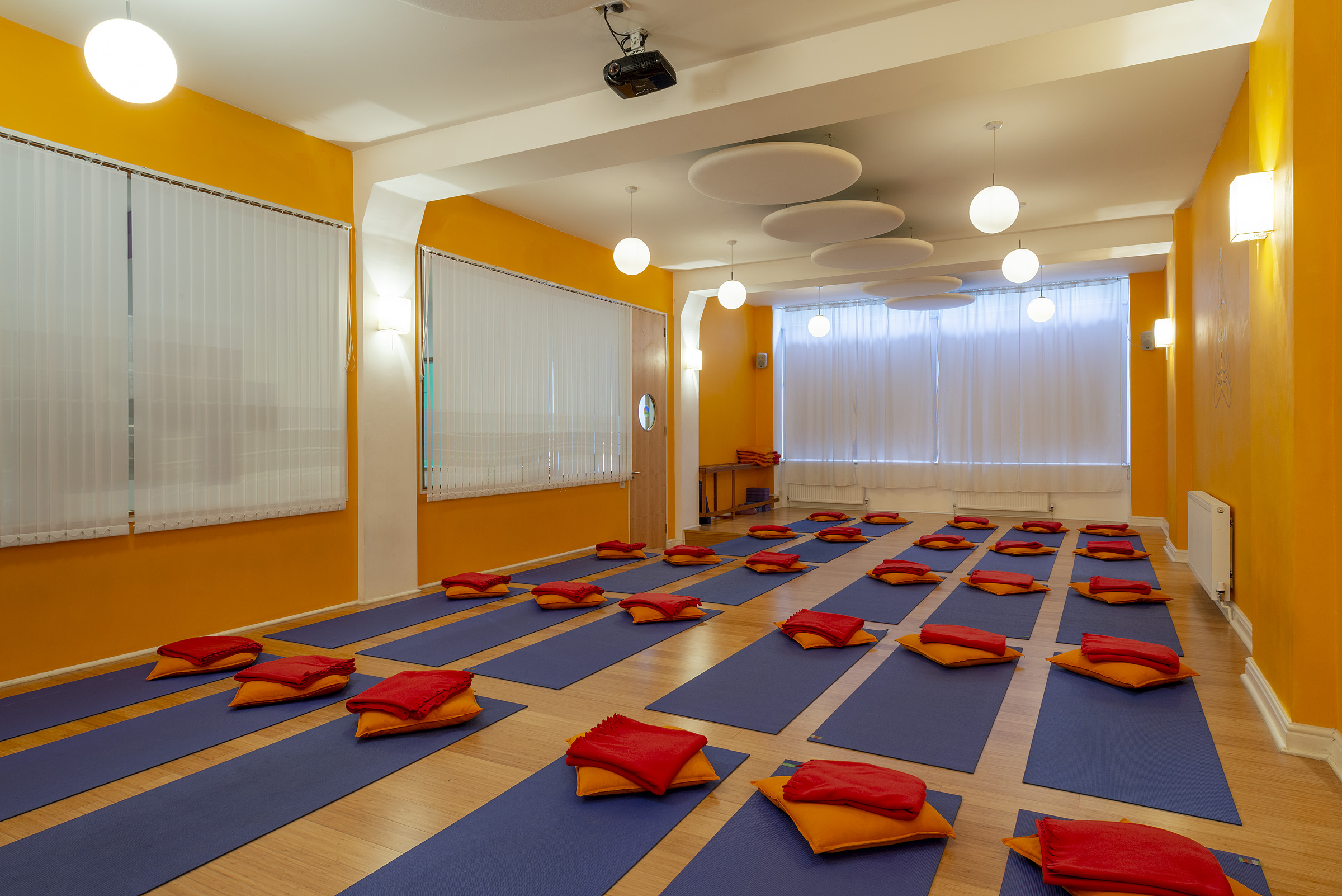 Vibrant yoga studio with orange walls, perfect for wellness events and mindfulness workshops.
