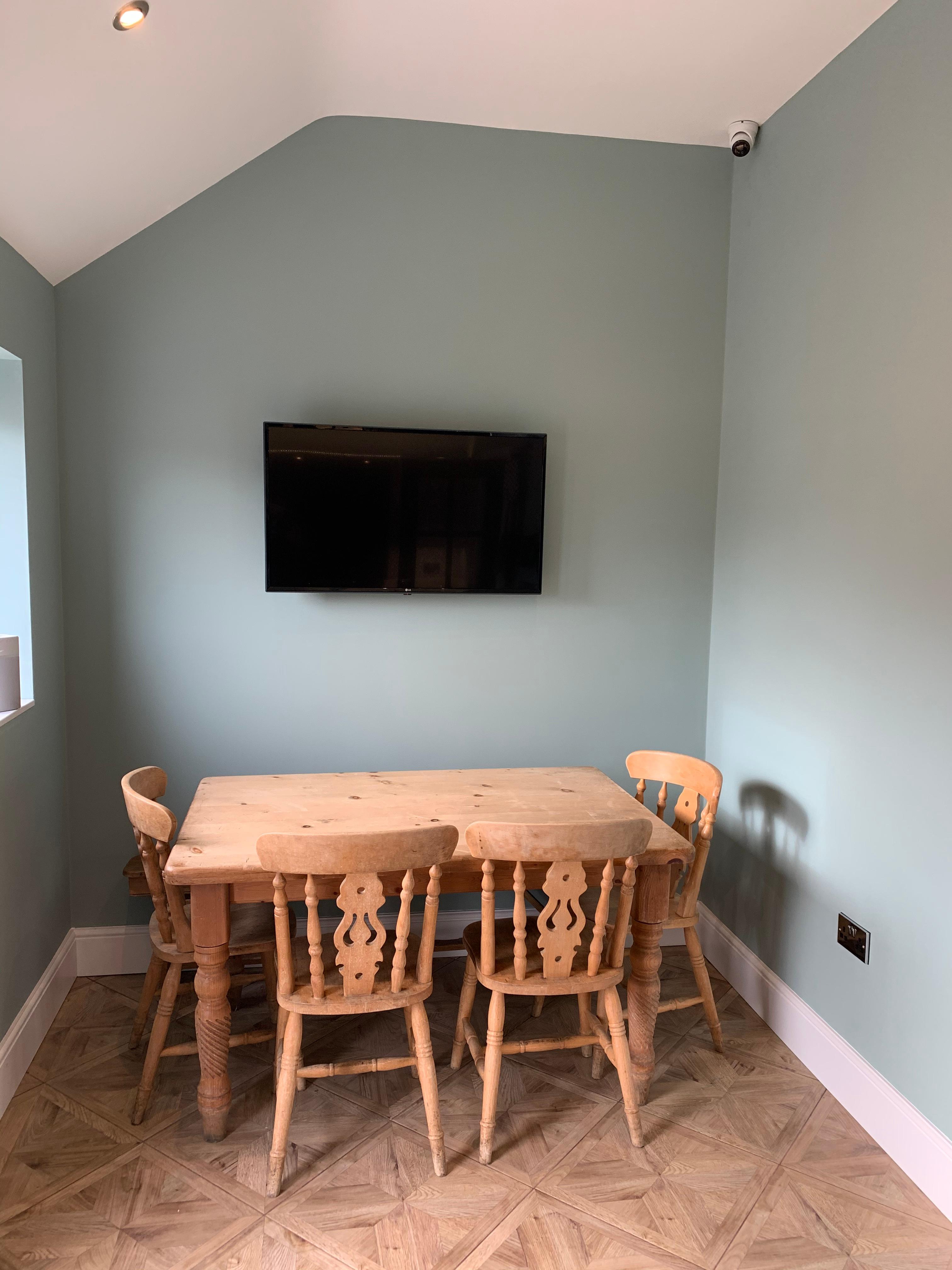 Lola The Victorian Summerhouse: minimalist meeting space with wooden table and chairs.