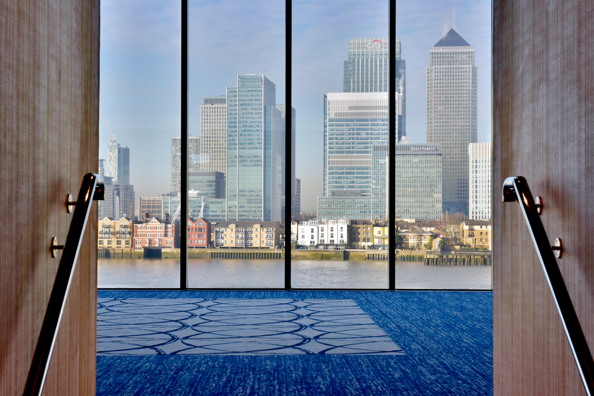 Modern event space at Riverview Suites, large windows, ideal for meetings and conferences.