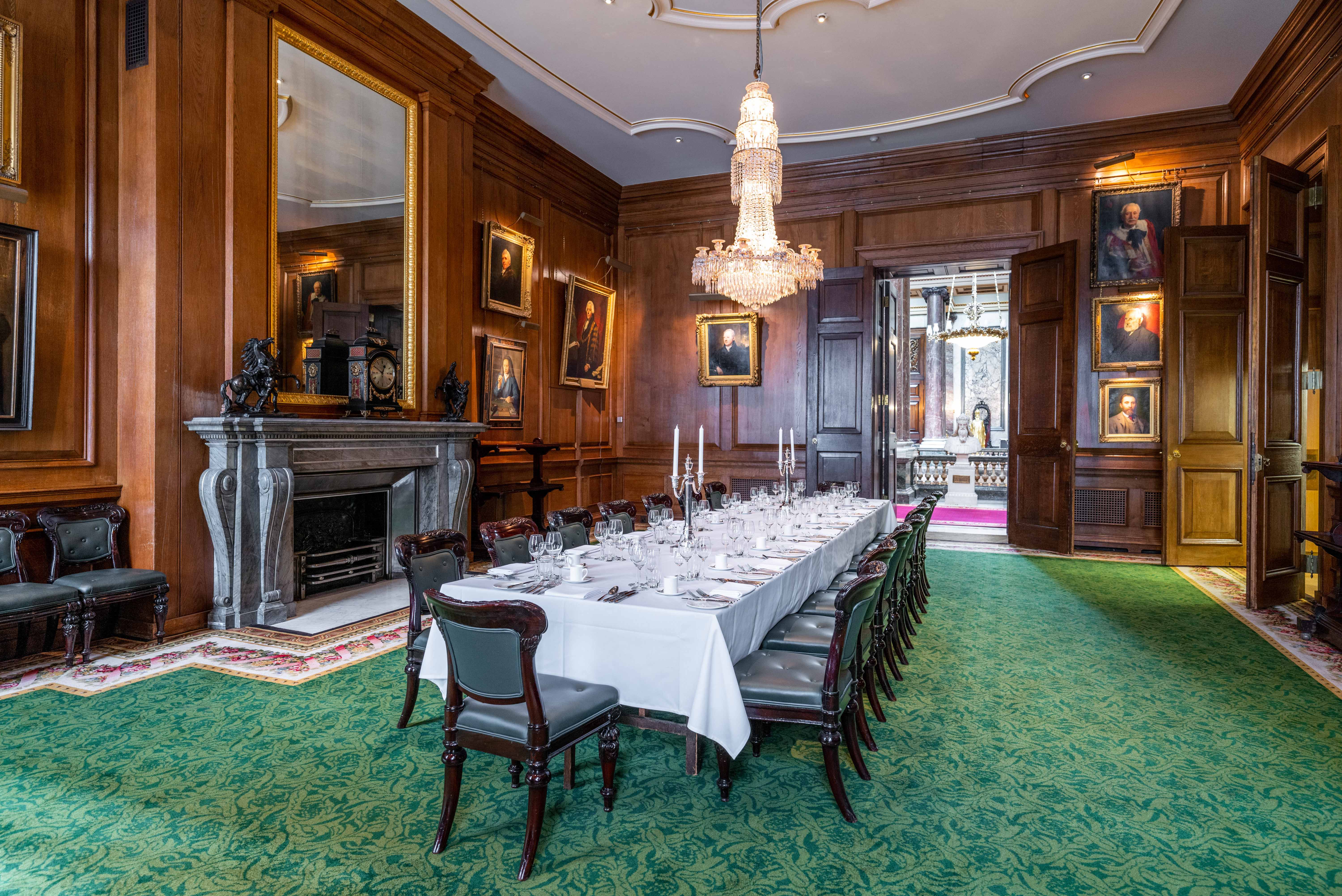 Elegant dining room at Goldsmiths' Hall, set for formal events with rich wood paneling.