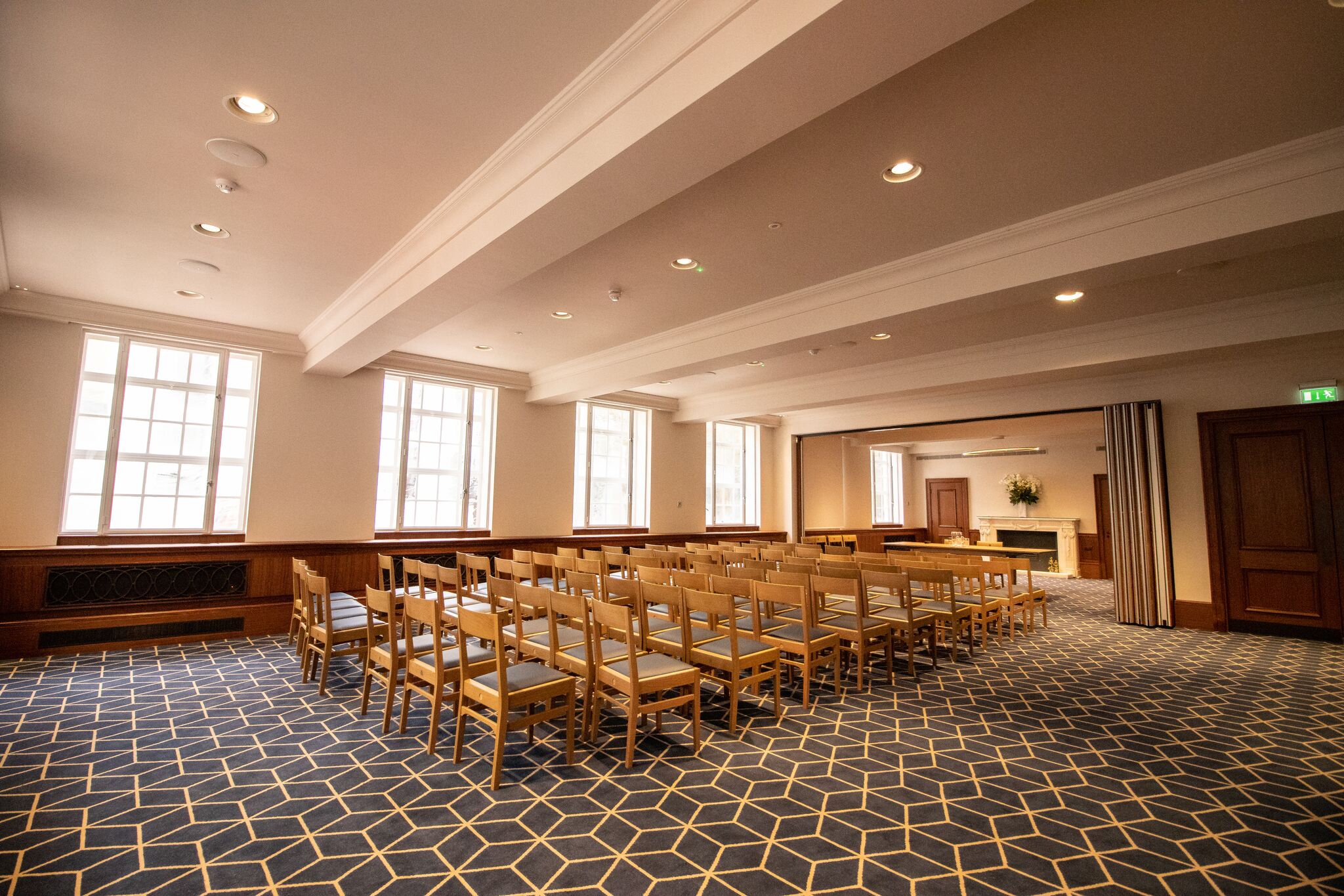 Well-lit meeting room with wooden chairs for corporate events and workshops.