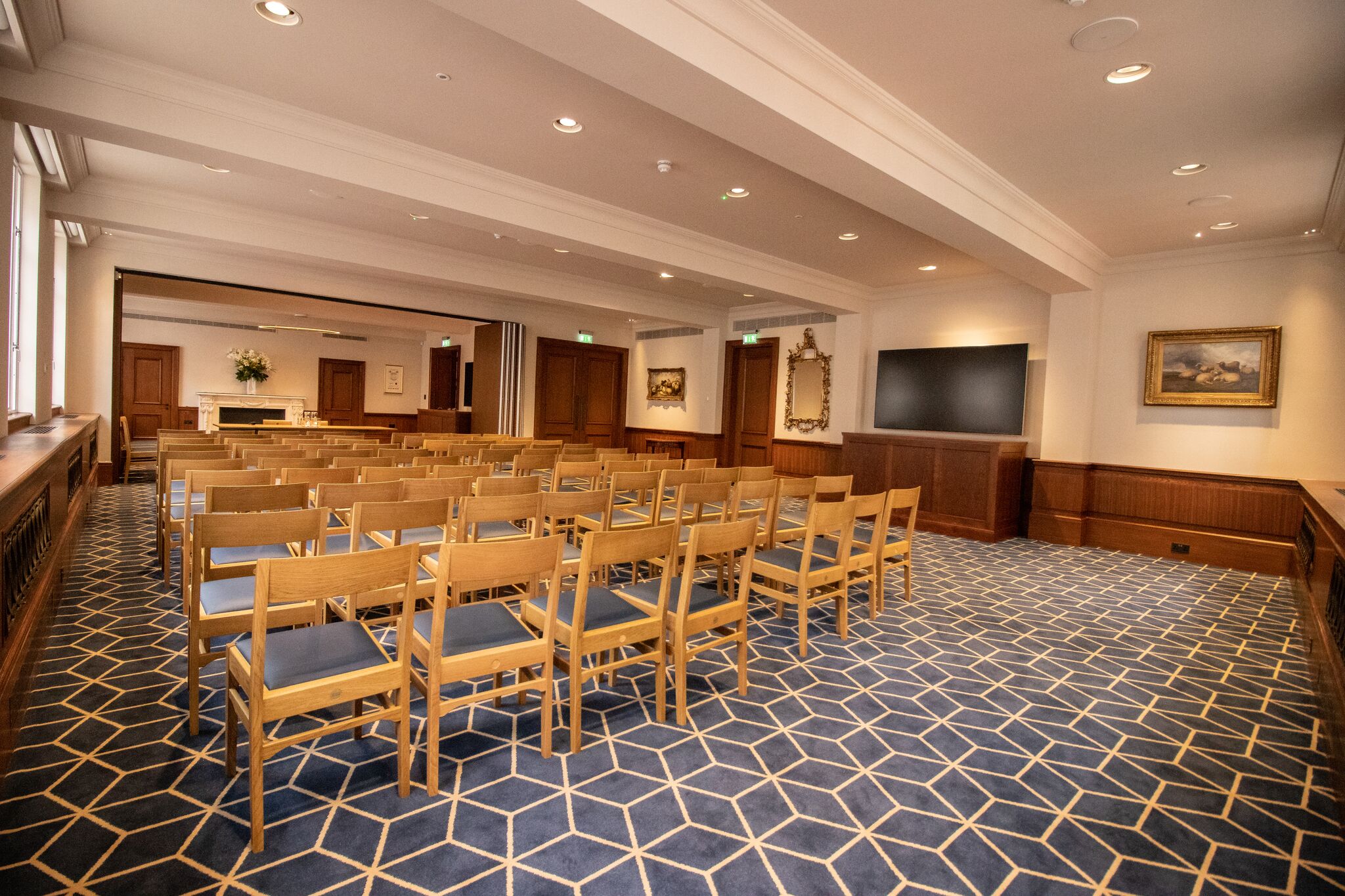 Meeting room at Court Suites with large screen, ideal for corporate events and presentations.