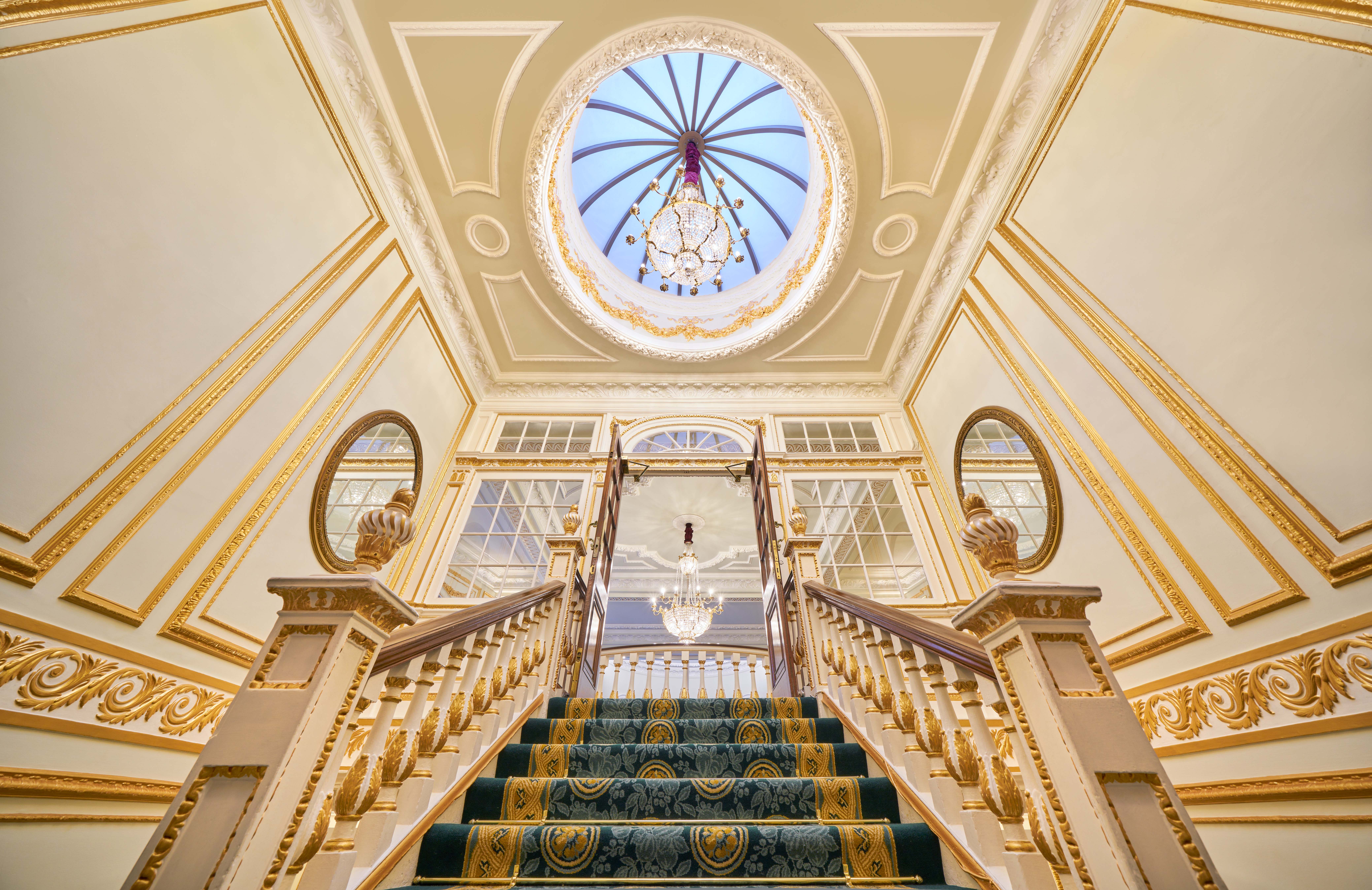 Elegant Aldwych Theatre staircase with chandelier, perfect for upscale events and meetings.
