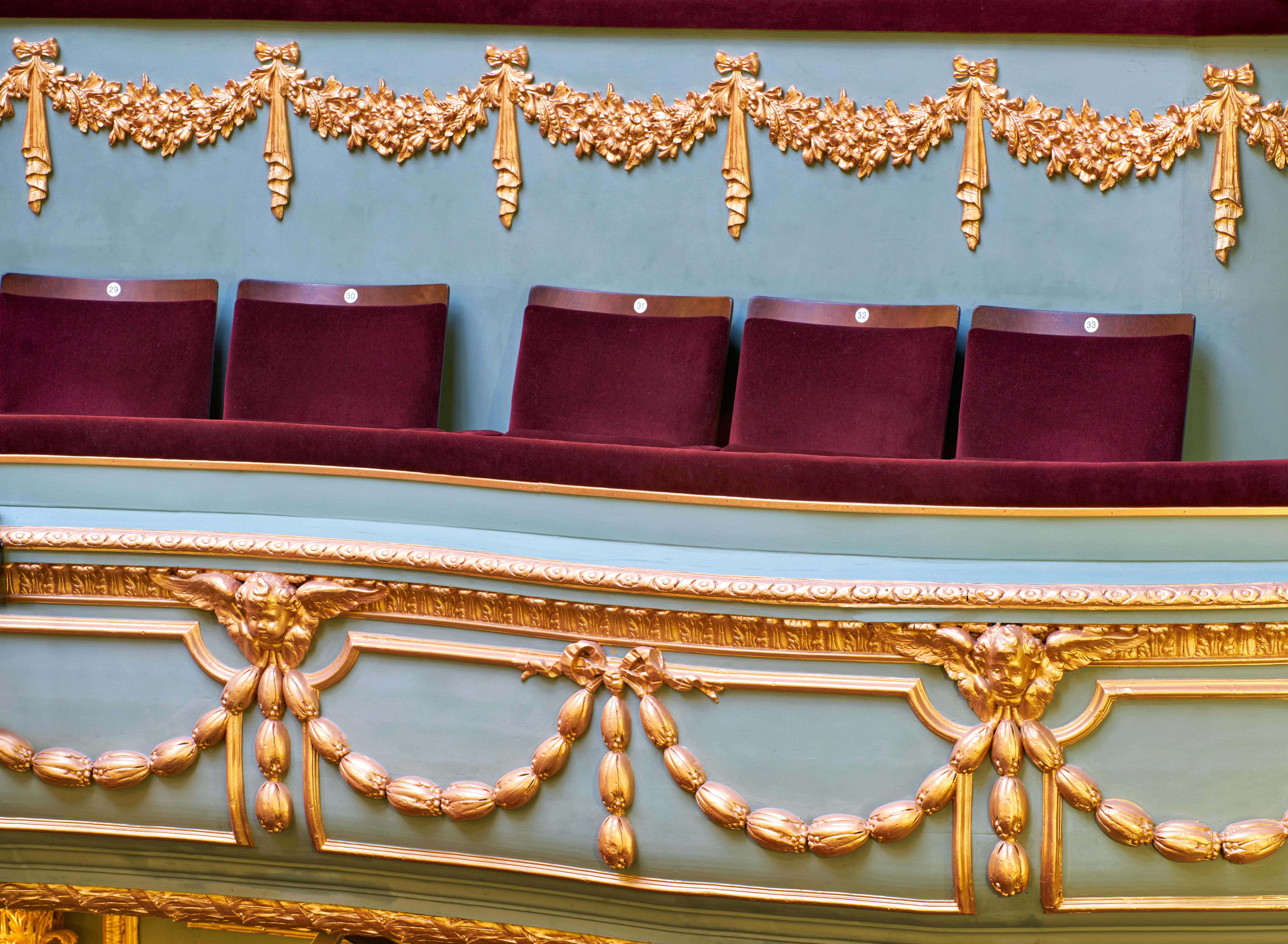 Aldwych Theatre box with maroon seating, perfect for exclusive events and gatherings.