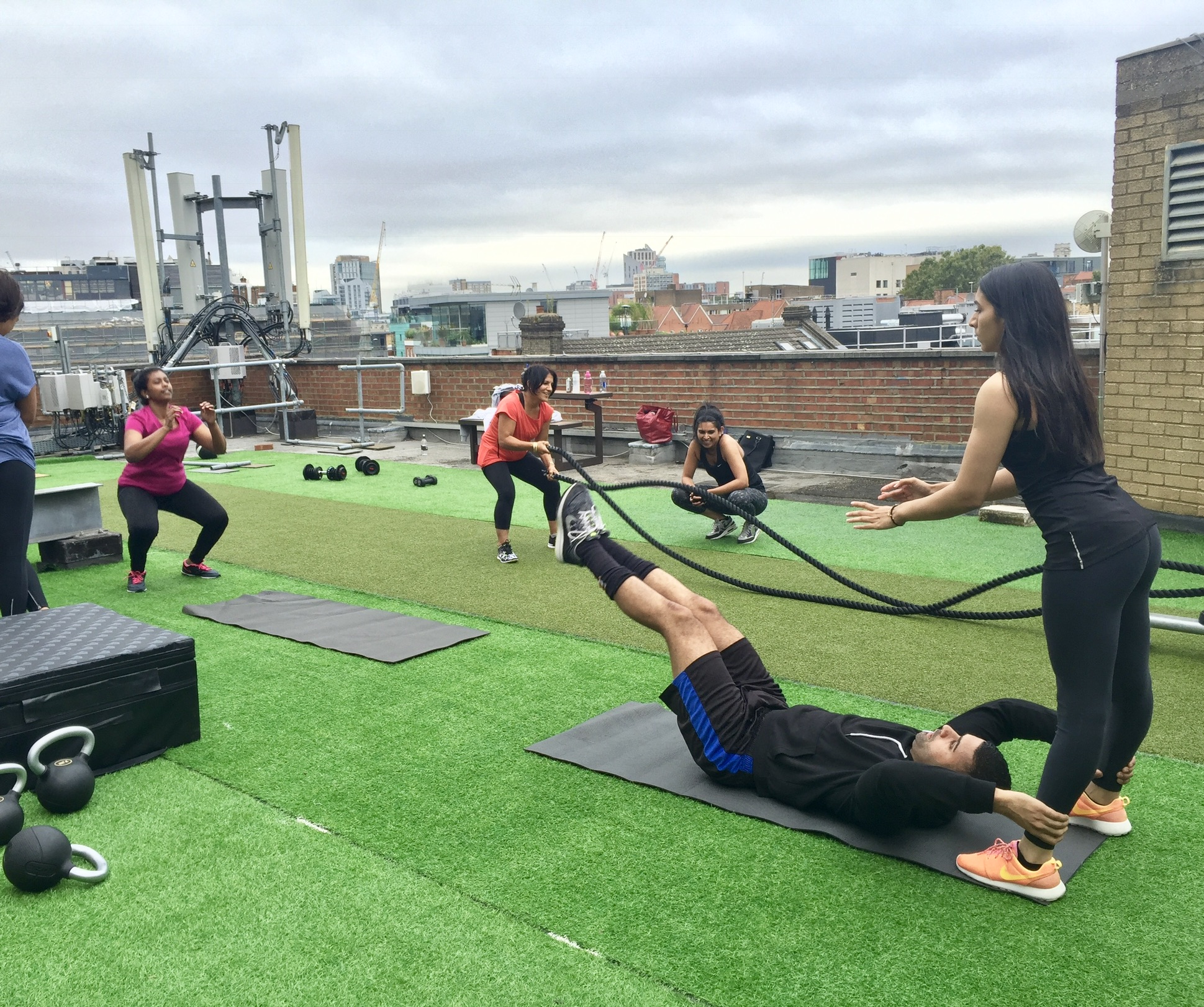 Outdoor fitness event at London rooftop gym, promoting wellness and team-building.