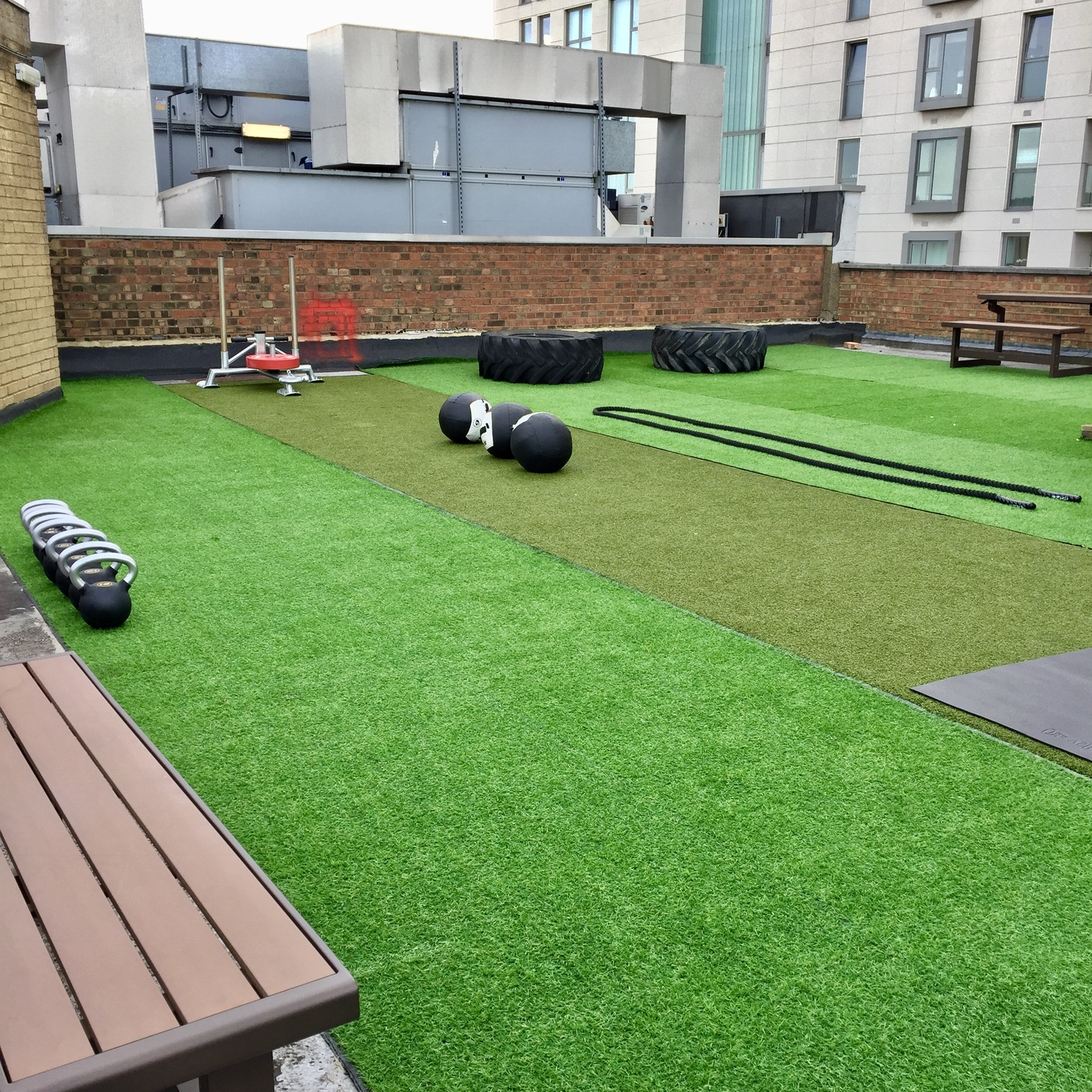 Rooftop gym in London with artificial turf for fitness events and team-building activities.