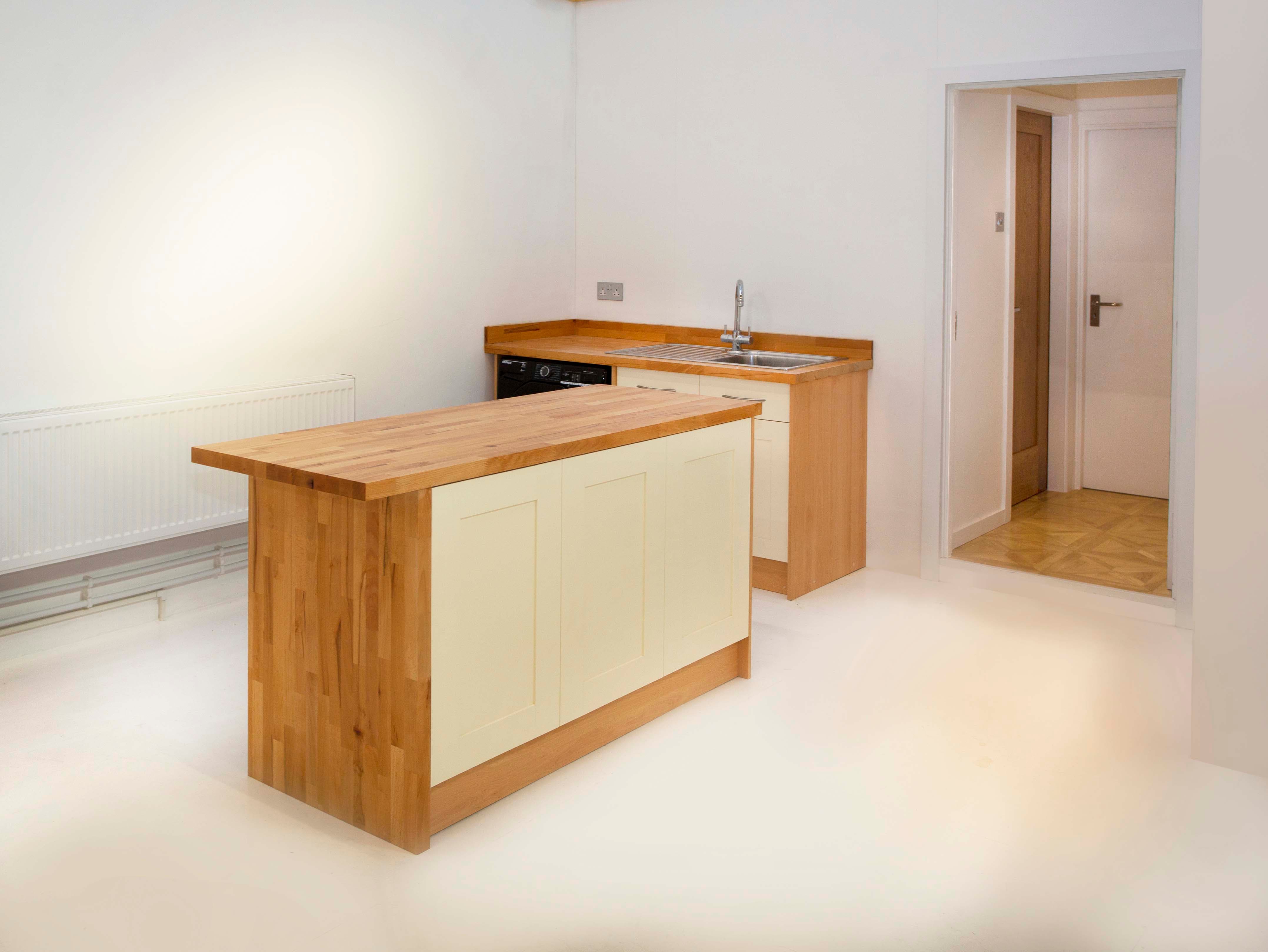 Modern kitchen venue with central island for cooking classes and culinary events.