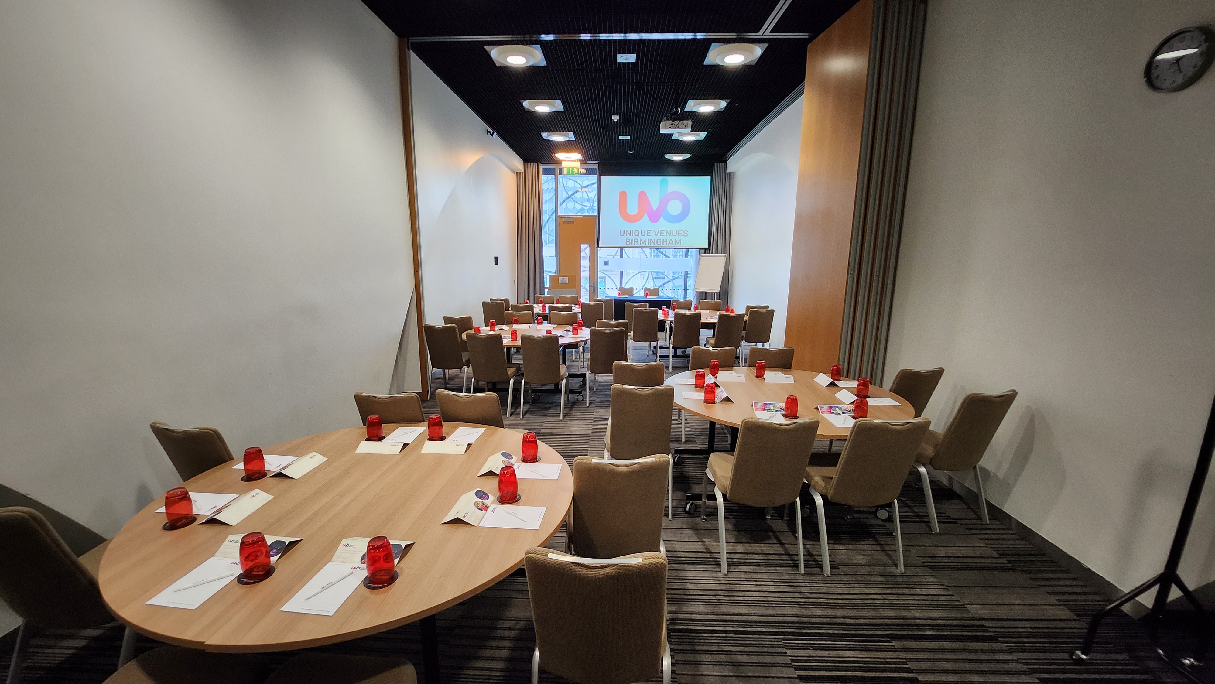 Meeting space LOB 103 with round tables and red accents for workshops and seminars.