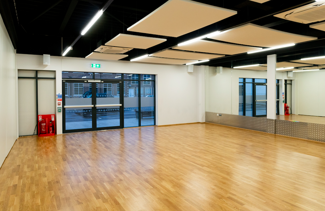 Dance studio with polished wooden floor, ideal for workshops and fitness classes.