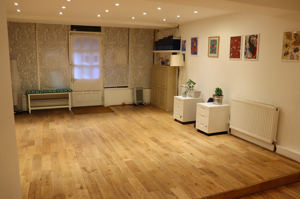 Versatile event space with wooden flooring, ideal for workshops and gatherings.