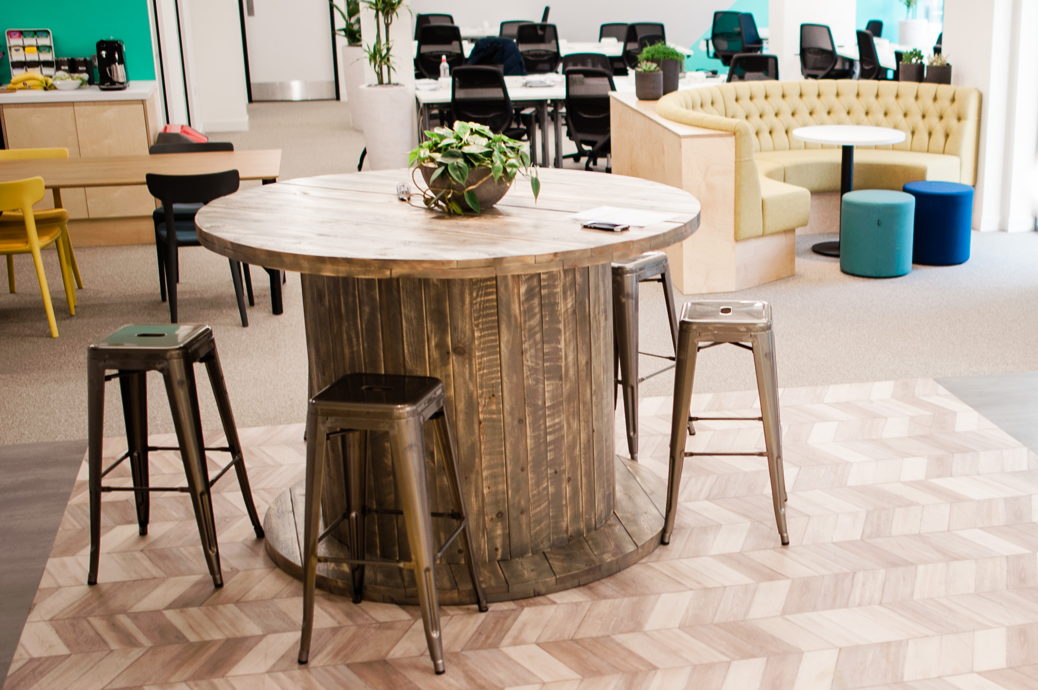 Modern meeting space with round wooden table, ideal for brainstorming and gatherings.