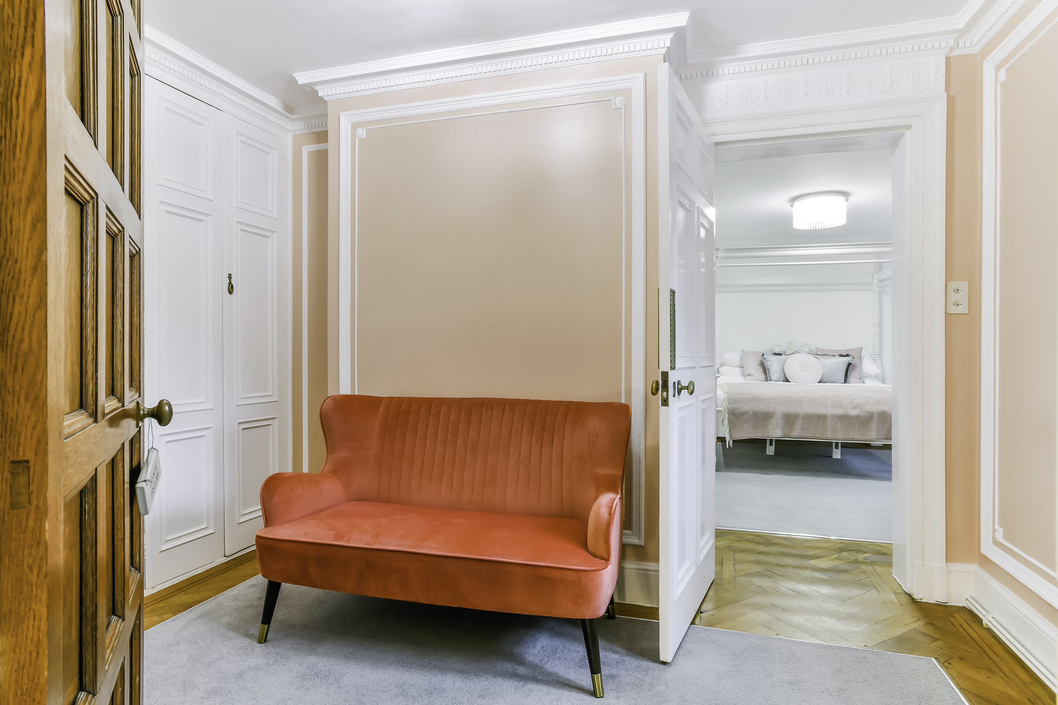 "Kingswood Manor entryway with orange sofa, perfect for events and networking."