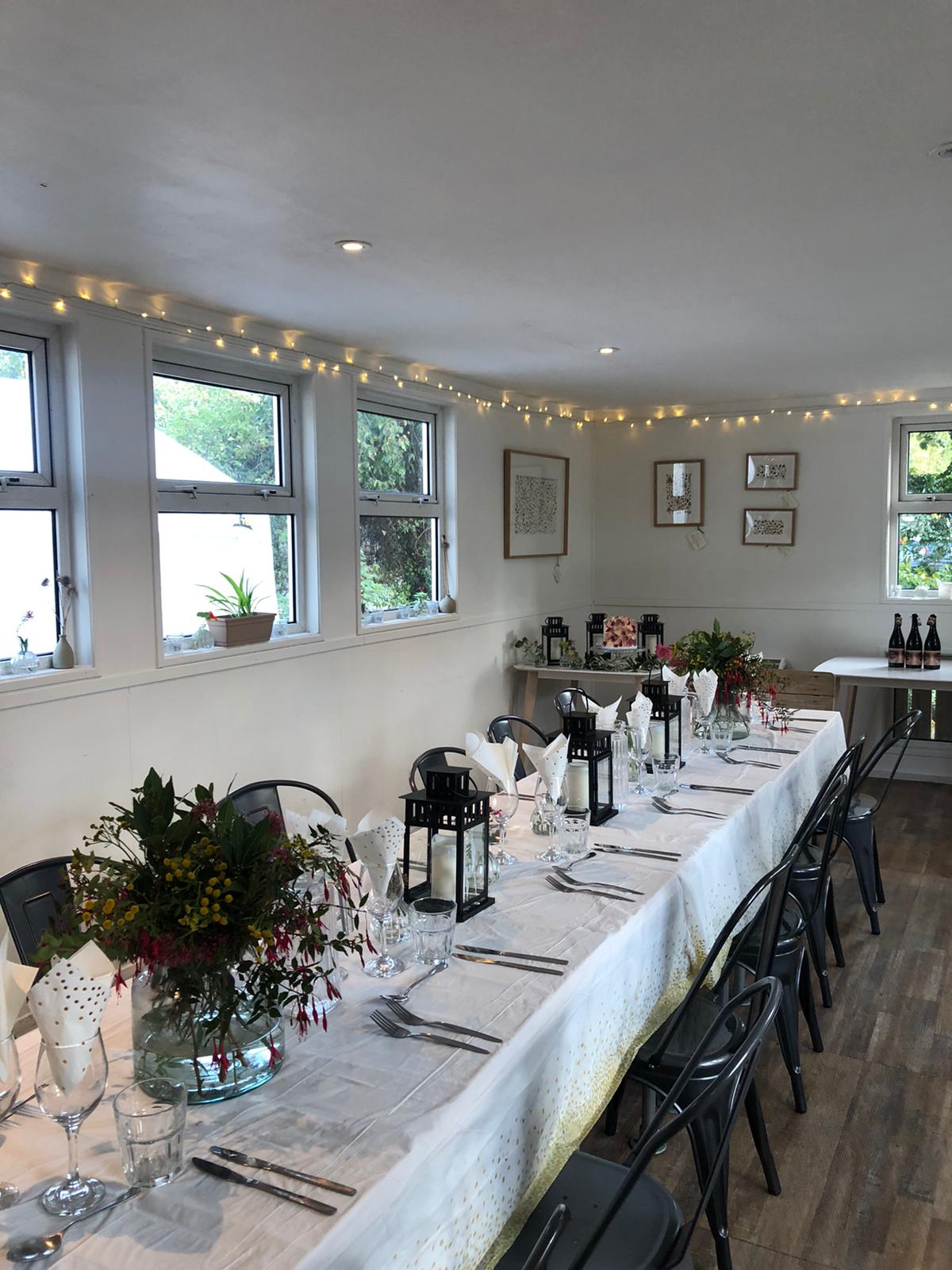 Elegant event space with long table, flowers, ideal for gatherings and meetings.