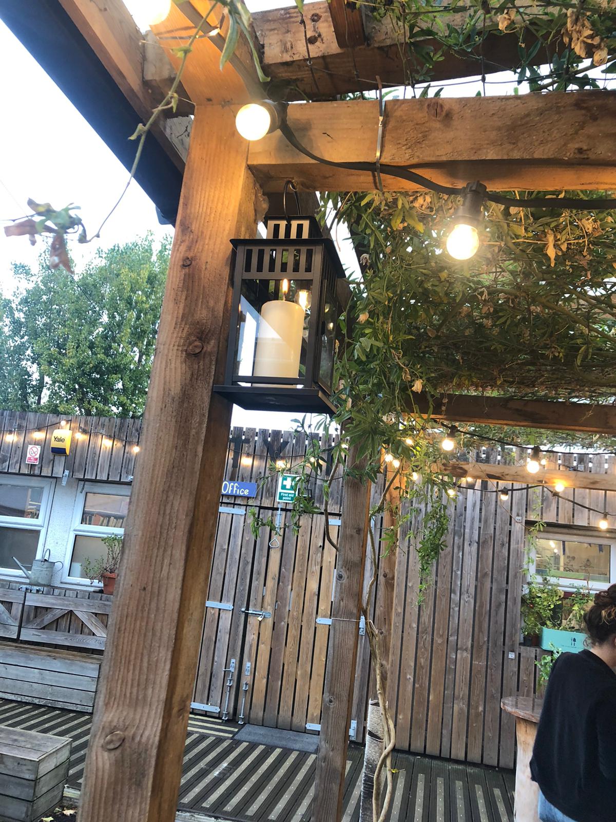 Outdoor event venue with rustic charm, lanterns, and string lights for gatherings.