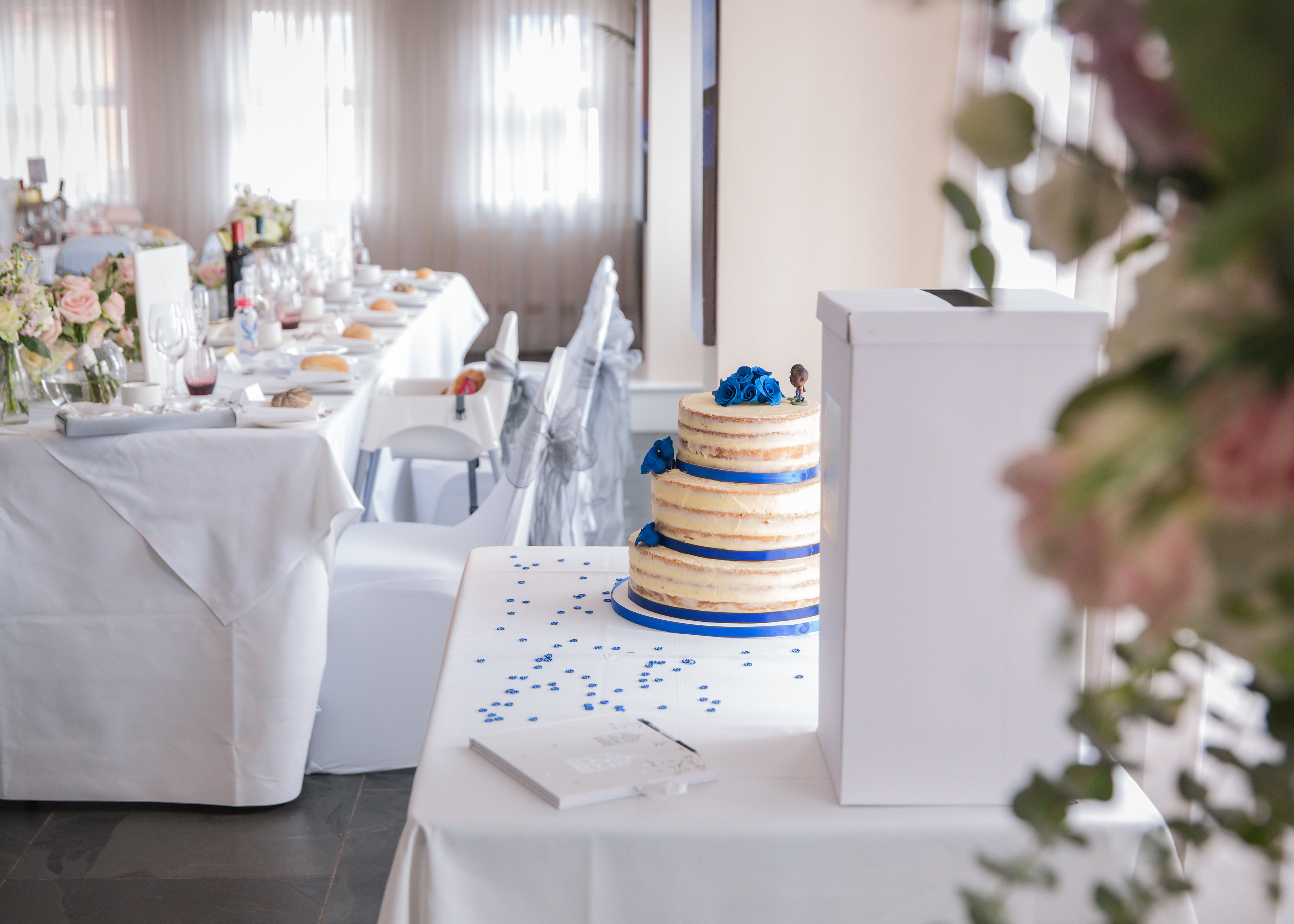 Elegant event space at Speroni's Restaurant, featuring floral centerpieces and a tiered cake.