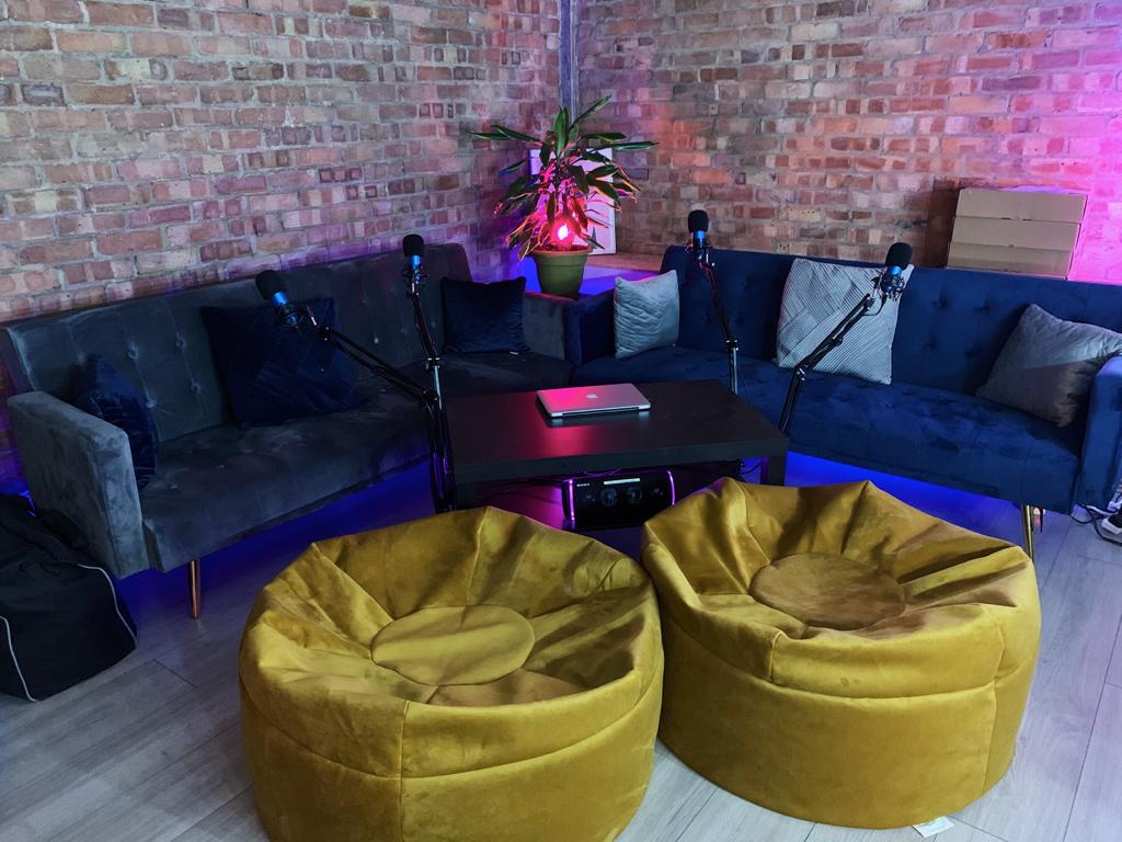 Cozy modern meeting space with plush sofas, ideal for podcasts and discussions.