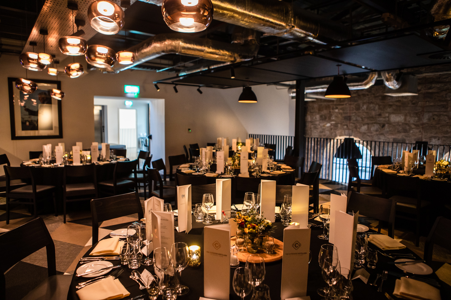 Elegant dinner setup at The Clydeside Distillery with round tables and polished glassware.