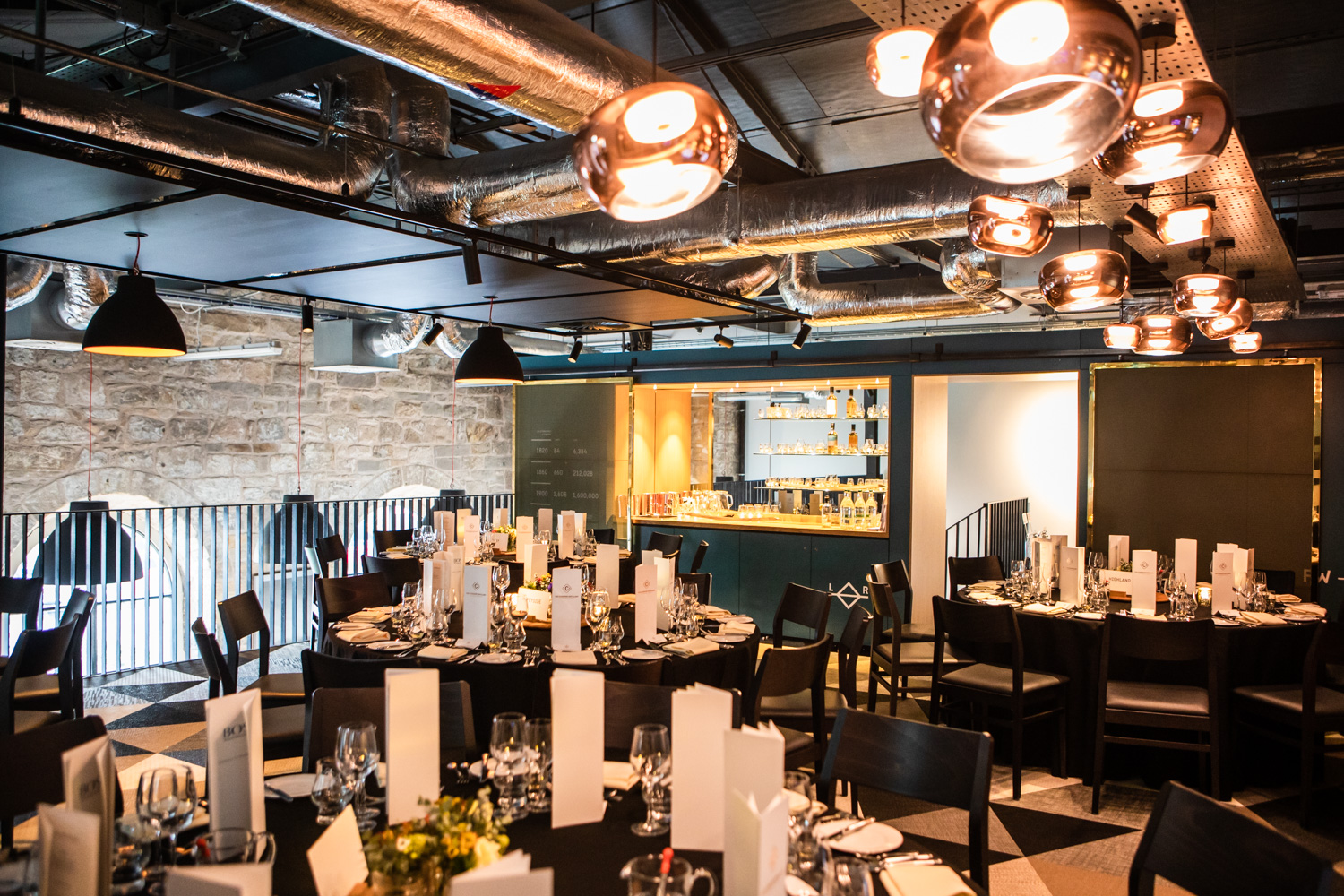 Elegant dinner setup at The Clydeside Distillery, featuring round tables and modern decor.