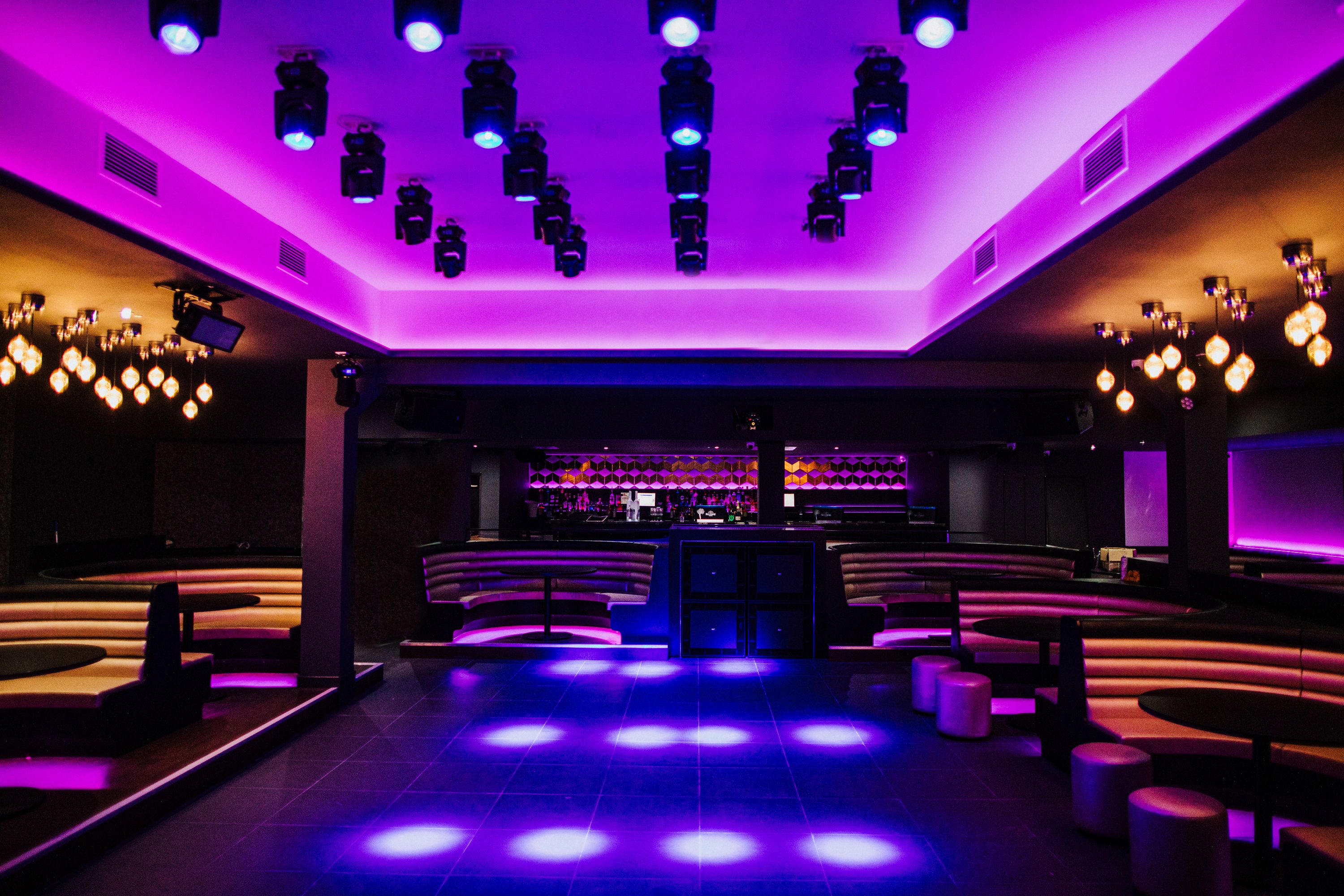 Modern event space with purple lighting, perfect for social and corporate gatherings.