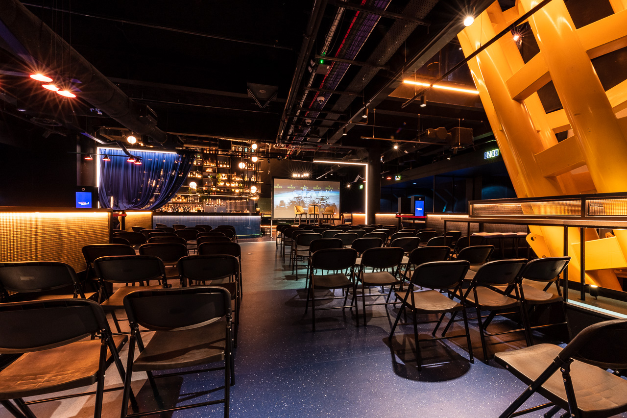Corner Bar at TOCA Social: modern event space with black chairs for presentations and gatherings.