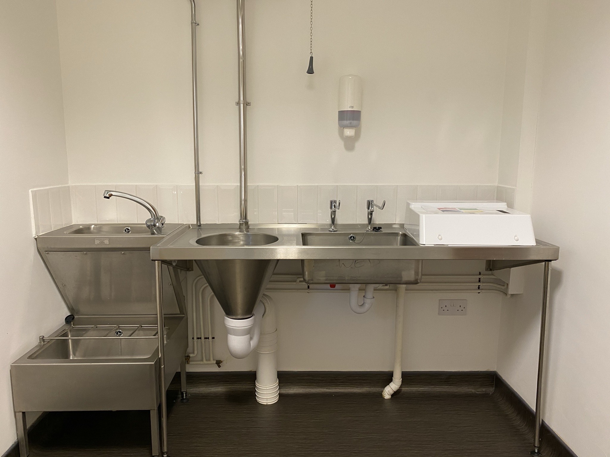 Catering prep area with stainless steel sinks at Pall Mall Medical & Cosmetic events.