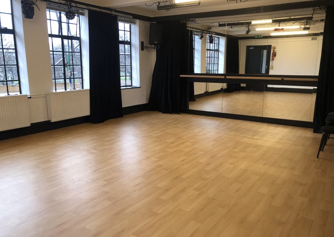 Versatile event space with mirrored wall, ideal for workshops and fitness classes.
