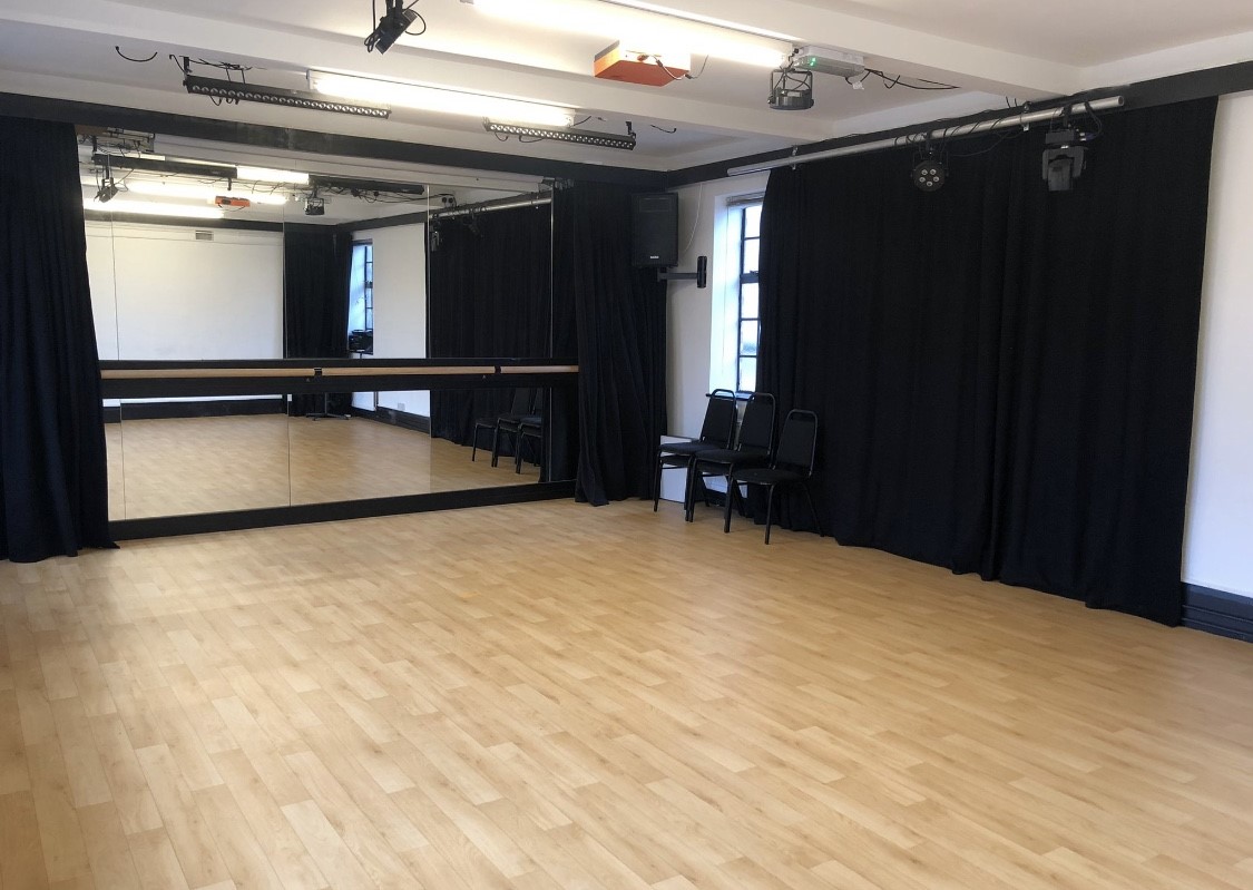 Versatile event space with polished wooden floor, ideal for dance classes and workshops.
