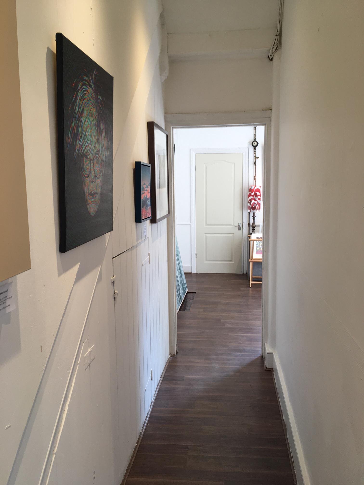 Narrow hallway with artwork in Ad Lib Gallery, perfect for networking events and workshops.
