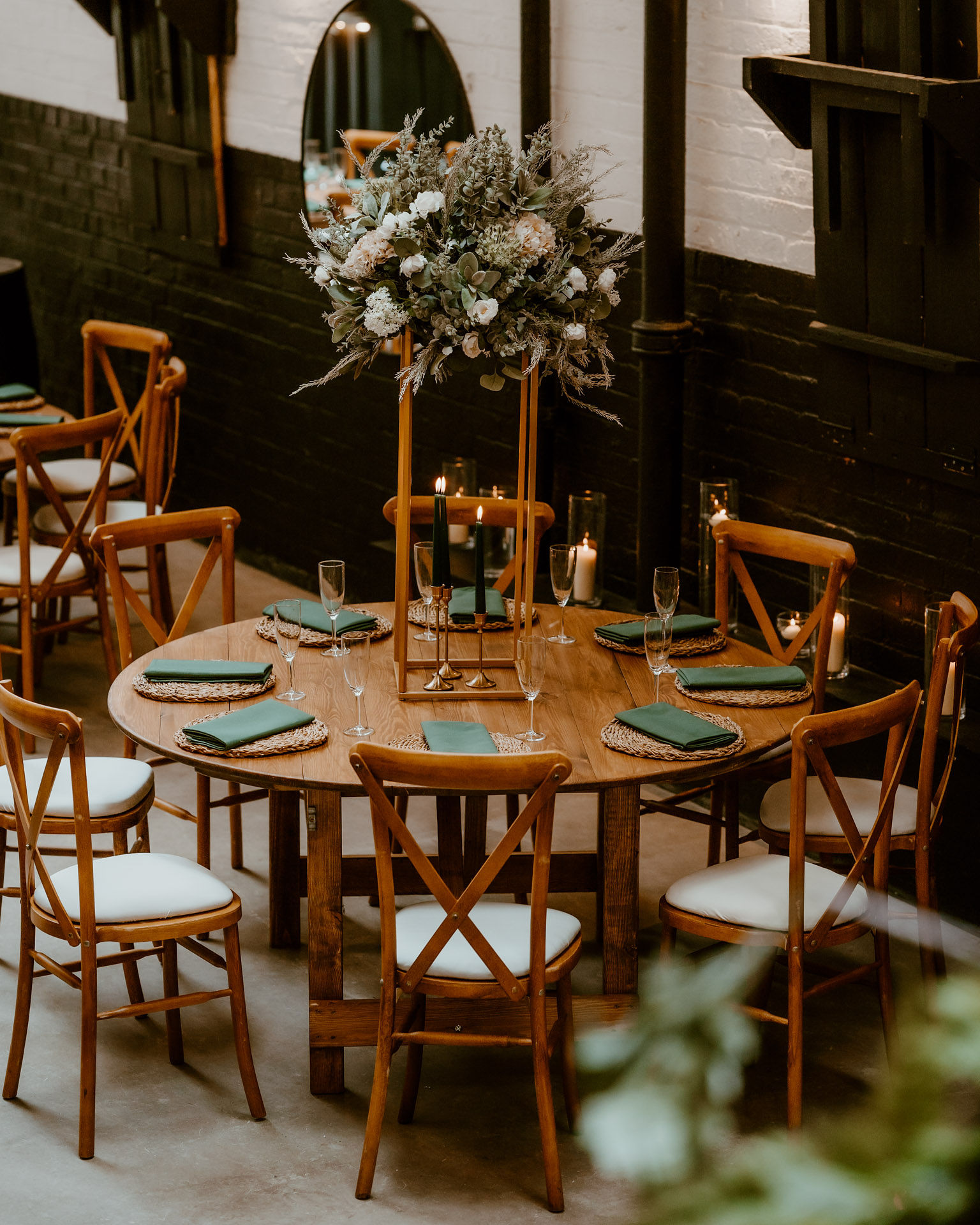 Elegant round table with greenery centerpiece for sophisticated events in Box Hub.