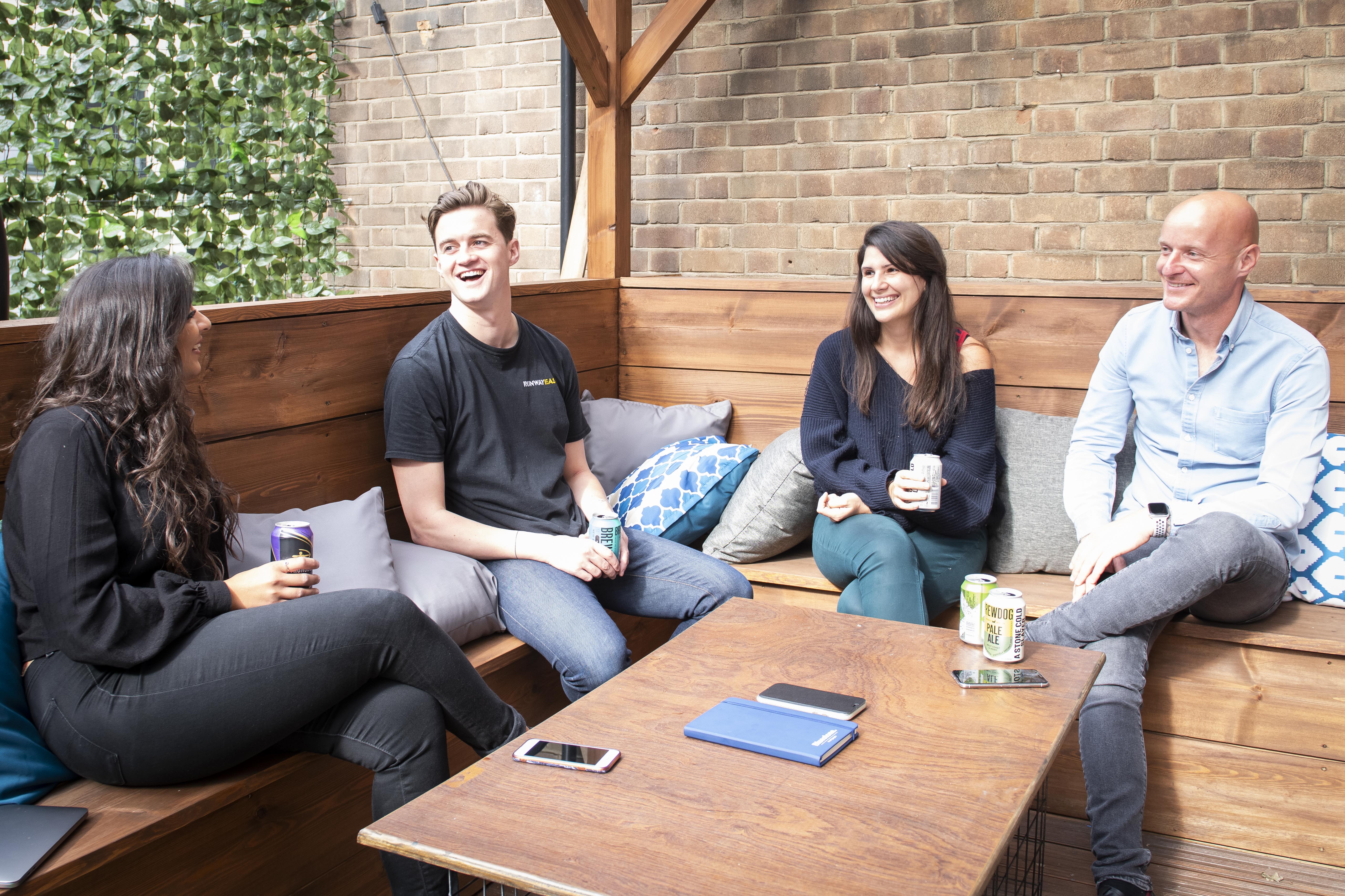 Casual meeting space at Runway East Soho with greenery, ideal for team-building activities.