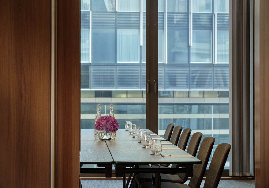 Modern Putney Suite meeting room with wooden table, ideal for intimate business events.